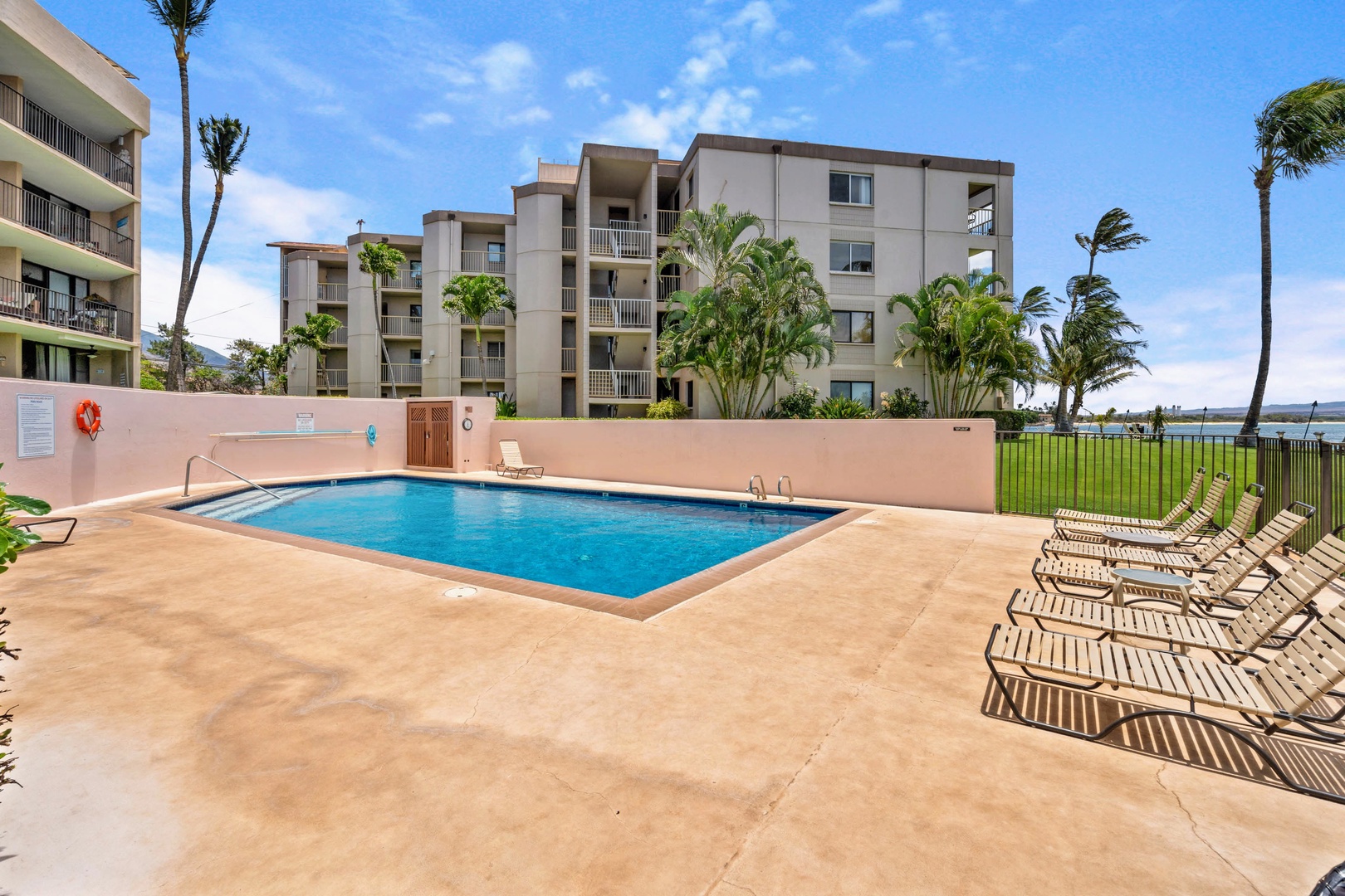 Wailuku Vacation Rentals, Milowai 310 - Stretch out on a lounge chair by the pool, with the building's palms swaying just past the fence.