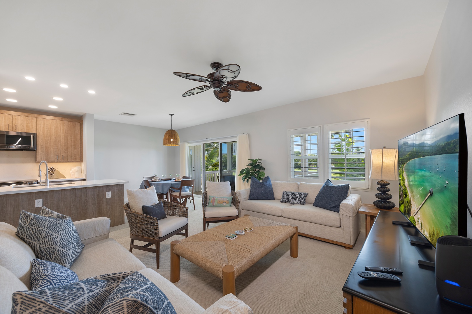 Relax in your bright, airy living space with comfortable seating, modern kitchen, and tropical ceiling fan keeping you cool.