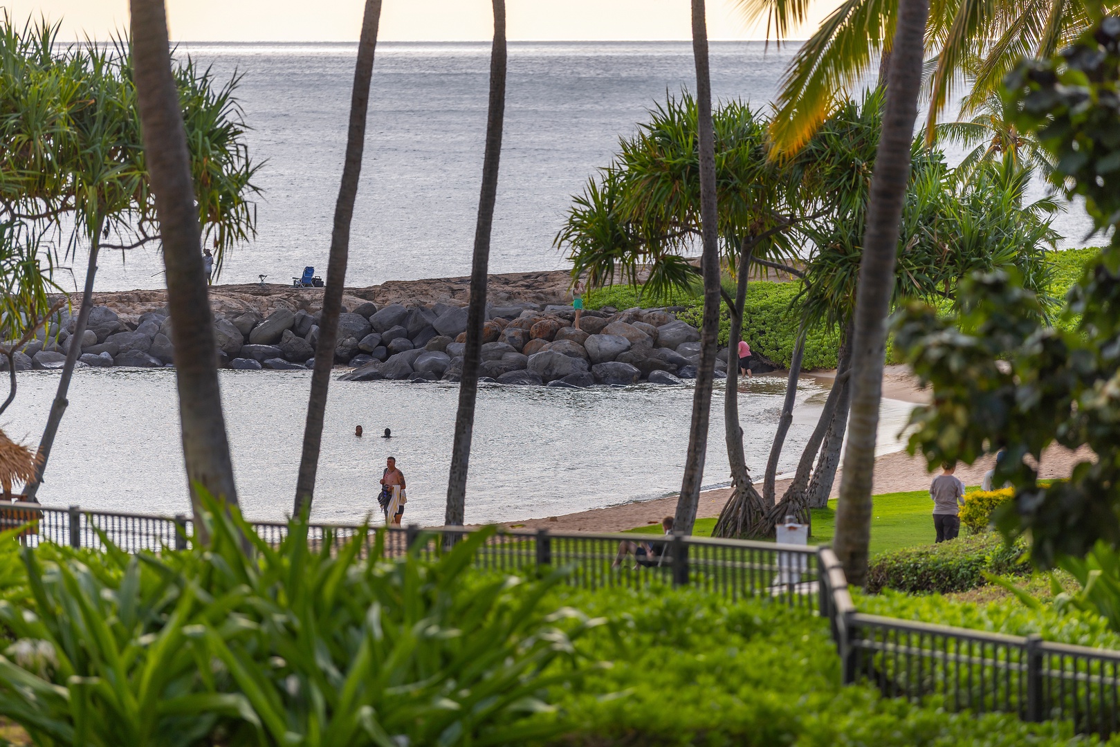Tranquil beachfront setting framed by swaying palms, with a sheltered lagoon and ocean beyond—a picturesque tropical escape awaits near the property.
