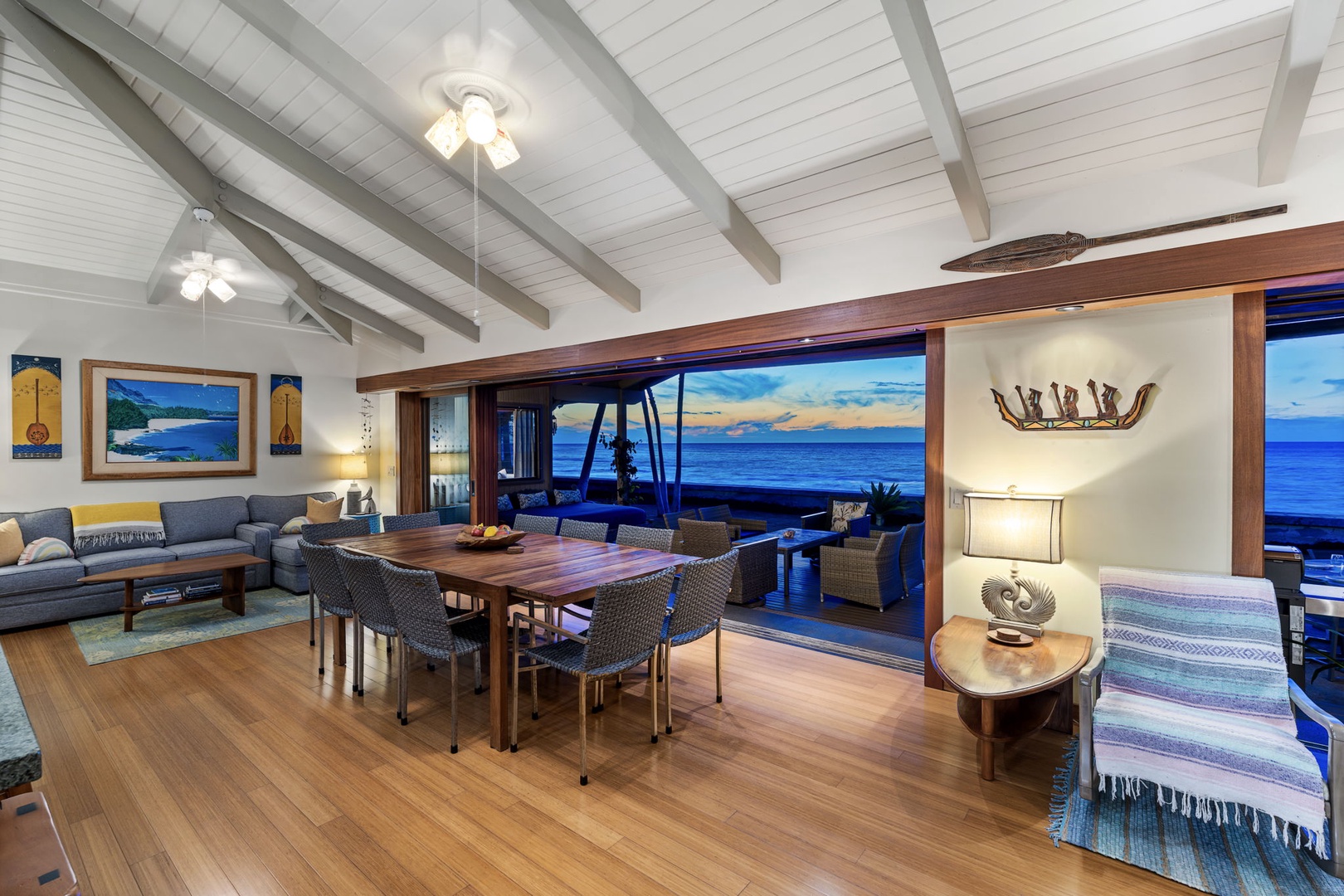 Kamuela Vacation Rentals, Island Time Retreat - The glass wall stays open into the evening, dining table set against the darkening sea.