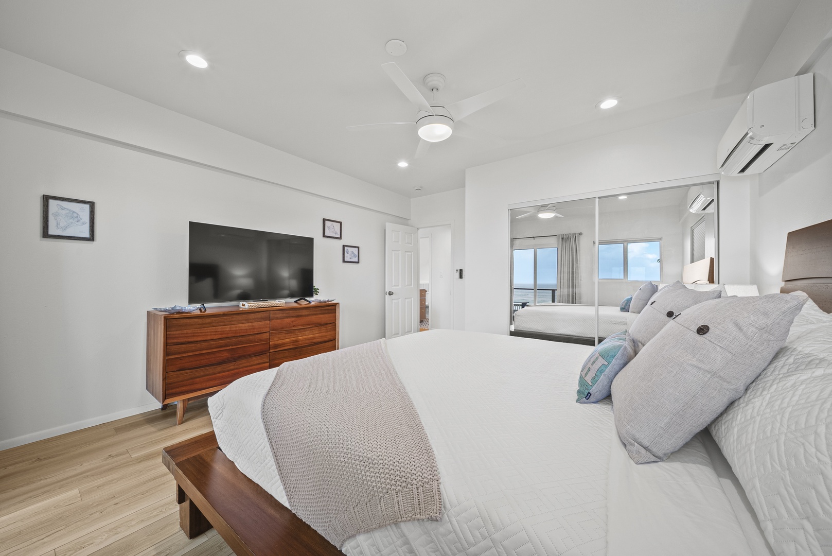 Haleiwa Vacation Rentals, Surfer's Paradise - Bedroom angle showcasing the room’s large TV and easy flow to the balcony, ideal for both relaxation and entertainment.