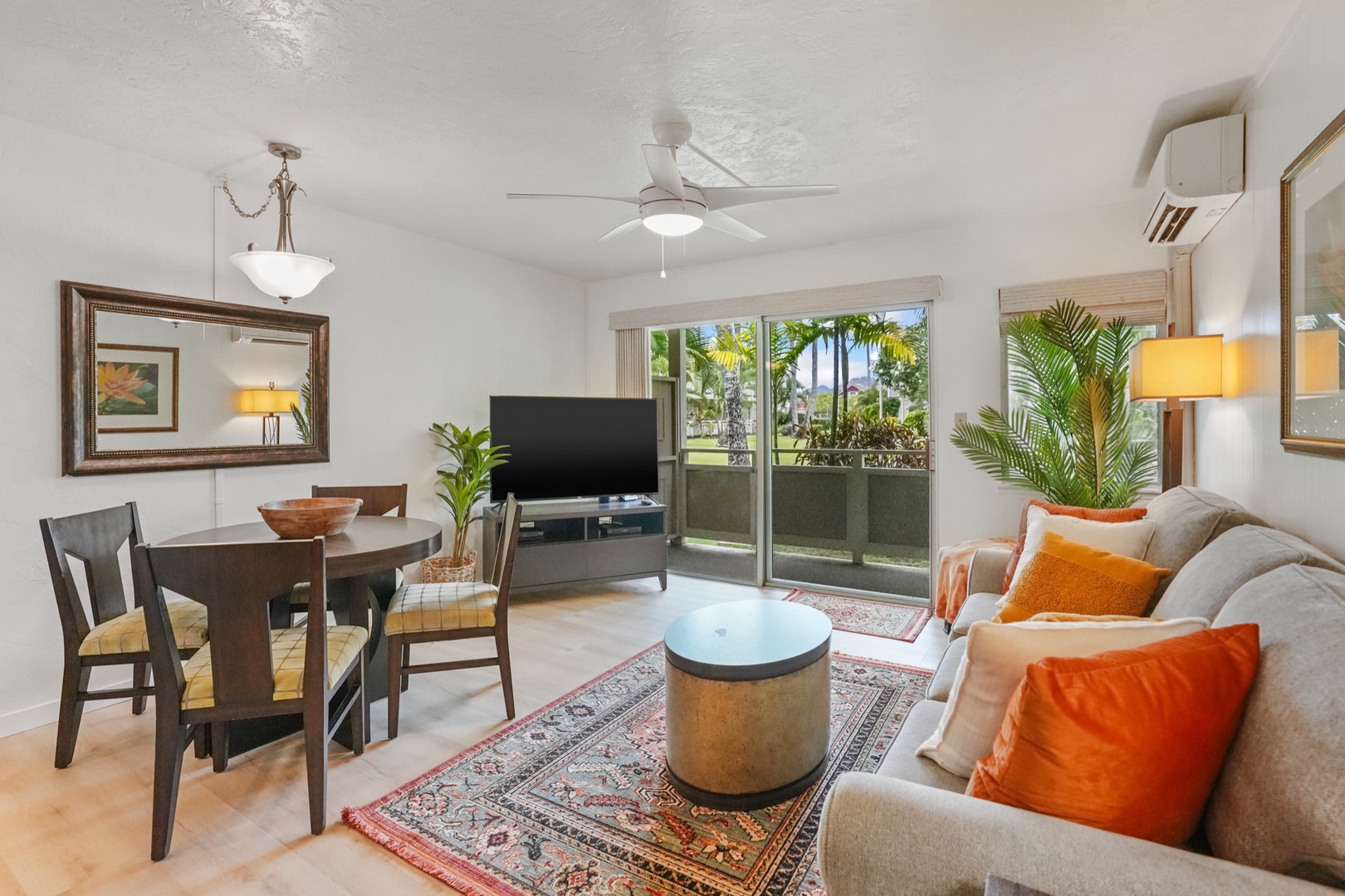 Kapaa Vacation Rentals, Kahaki Hale - Lounge in comfort on the queen-size sleeper sofa, with central A/C, a flat-screen TV, and sliding doors leading to your private lanai surrounded by tropical greenery.