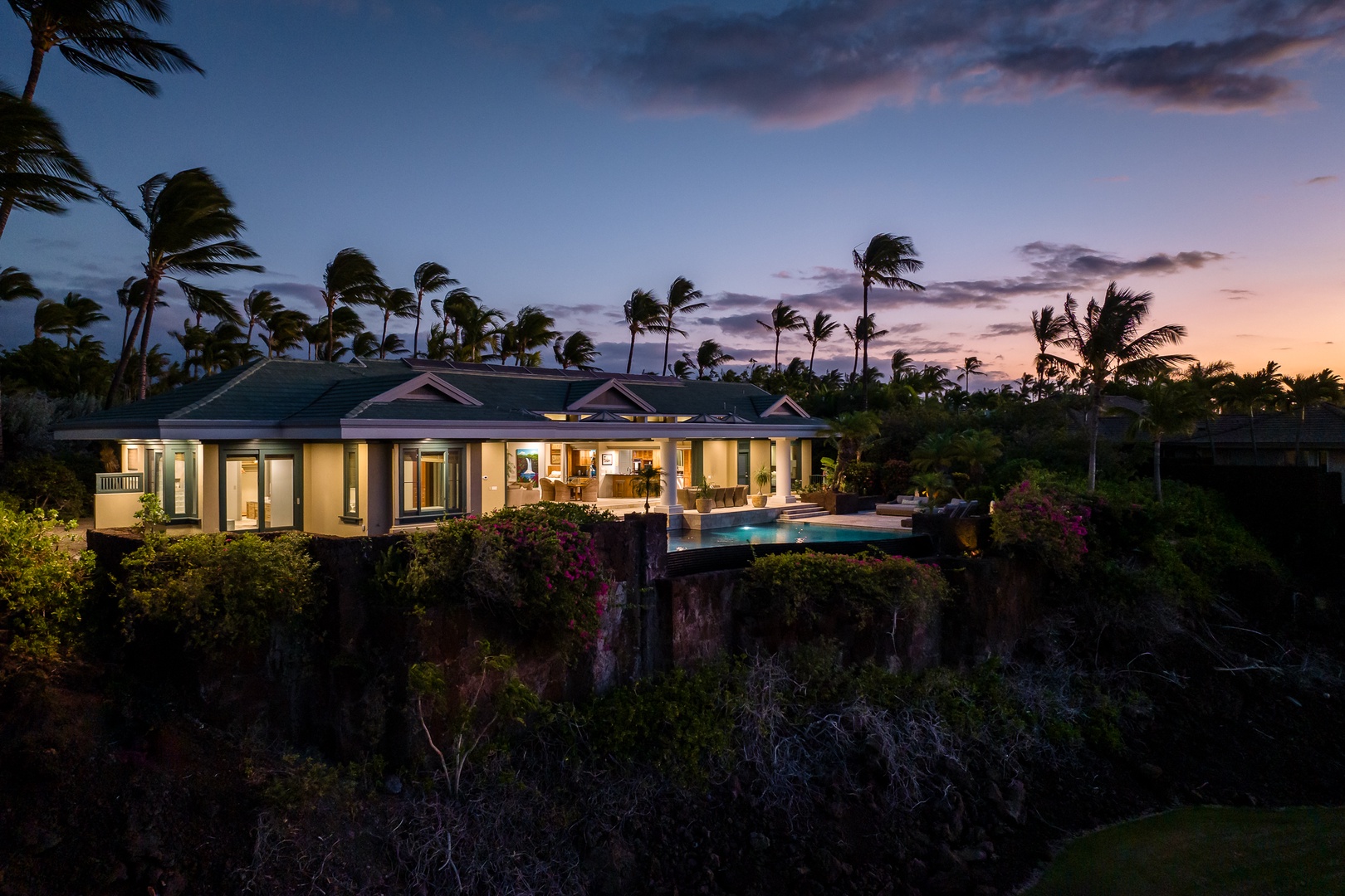 Kamuela Vacation Rentals, Champion Ridge 24 - Luxurious cliffside home at dusk, featuring an infinity pool and spacious outdoor living areas, surrounded by tropical beauty.