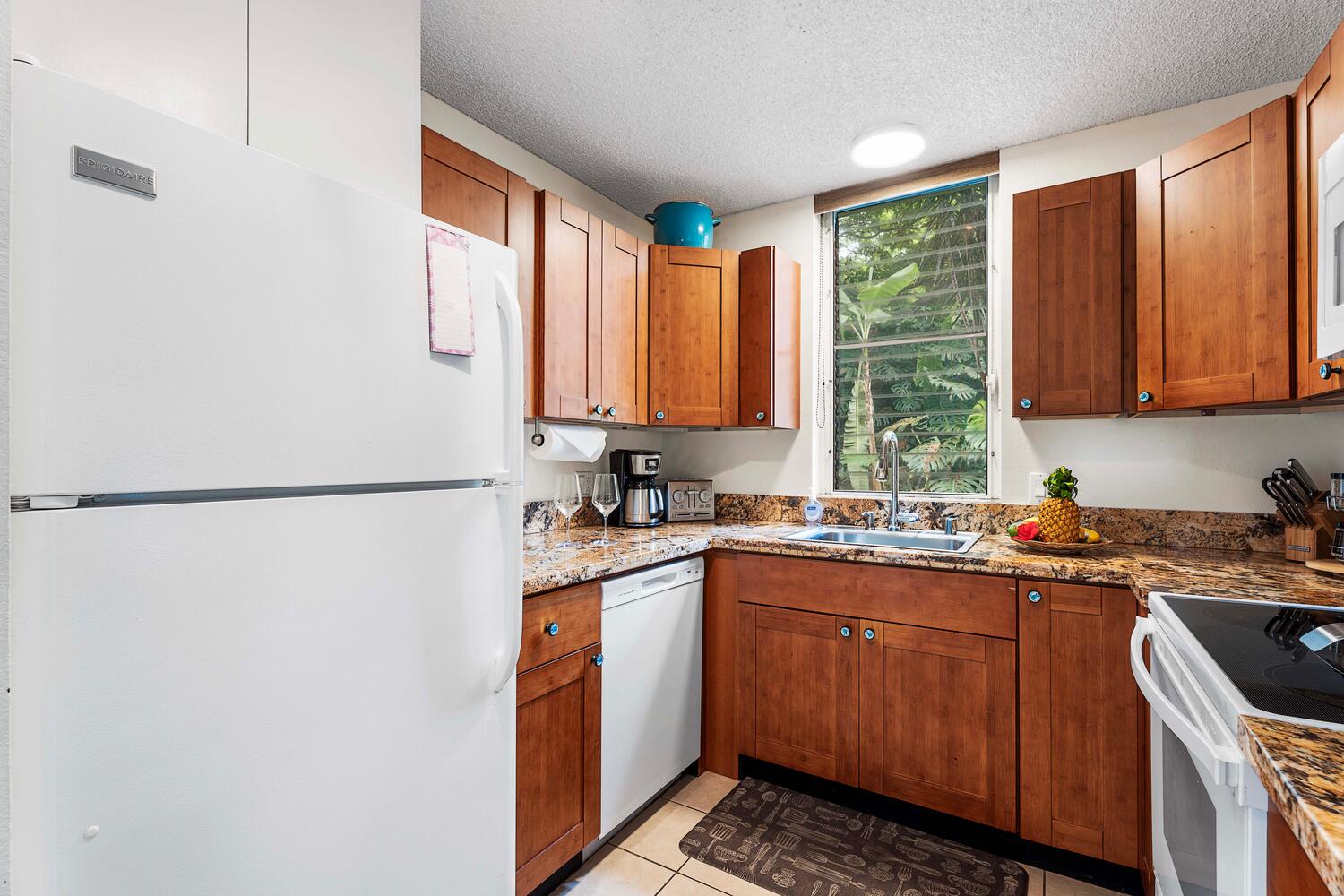 Kailua Kona Vacation Rentals, Keauhou Akahi 302 - A cozy kitchen with warm wood cabinetry, granite countertops, and essential appliances.