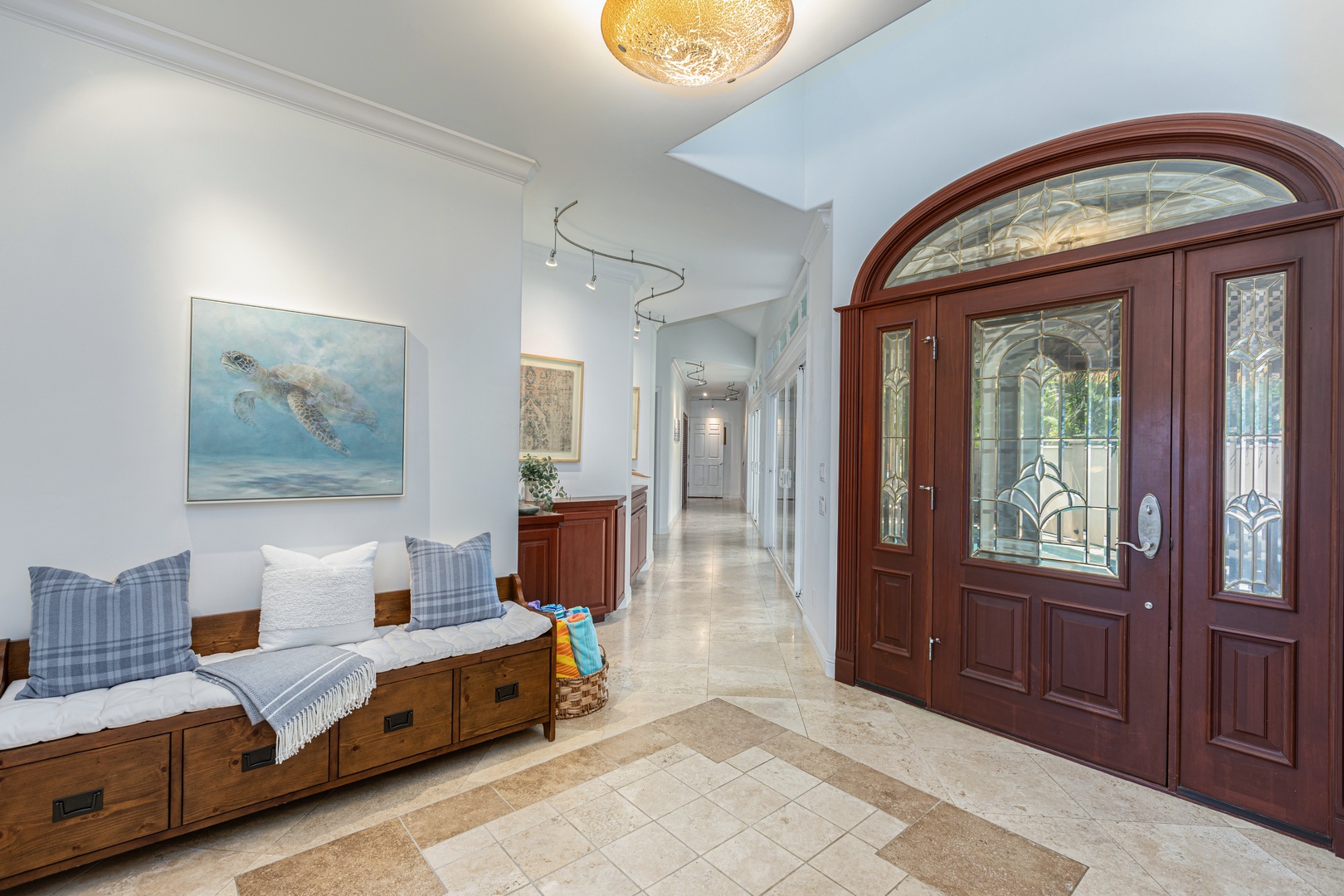 Princeville Vacation Rentals, Ohana Kamalani - Grand entry with arched doorway, natural stone flooring, and a welcoming, open layout.