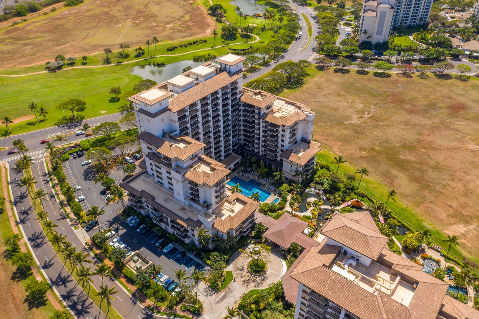 Kapolei Vacation Rentals, Ko Olina Beach Villas B604 - Aerial view of resort property with swimming pool, surrounded by golf course and tropical landscaping.