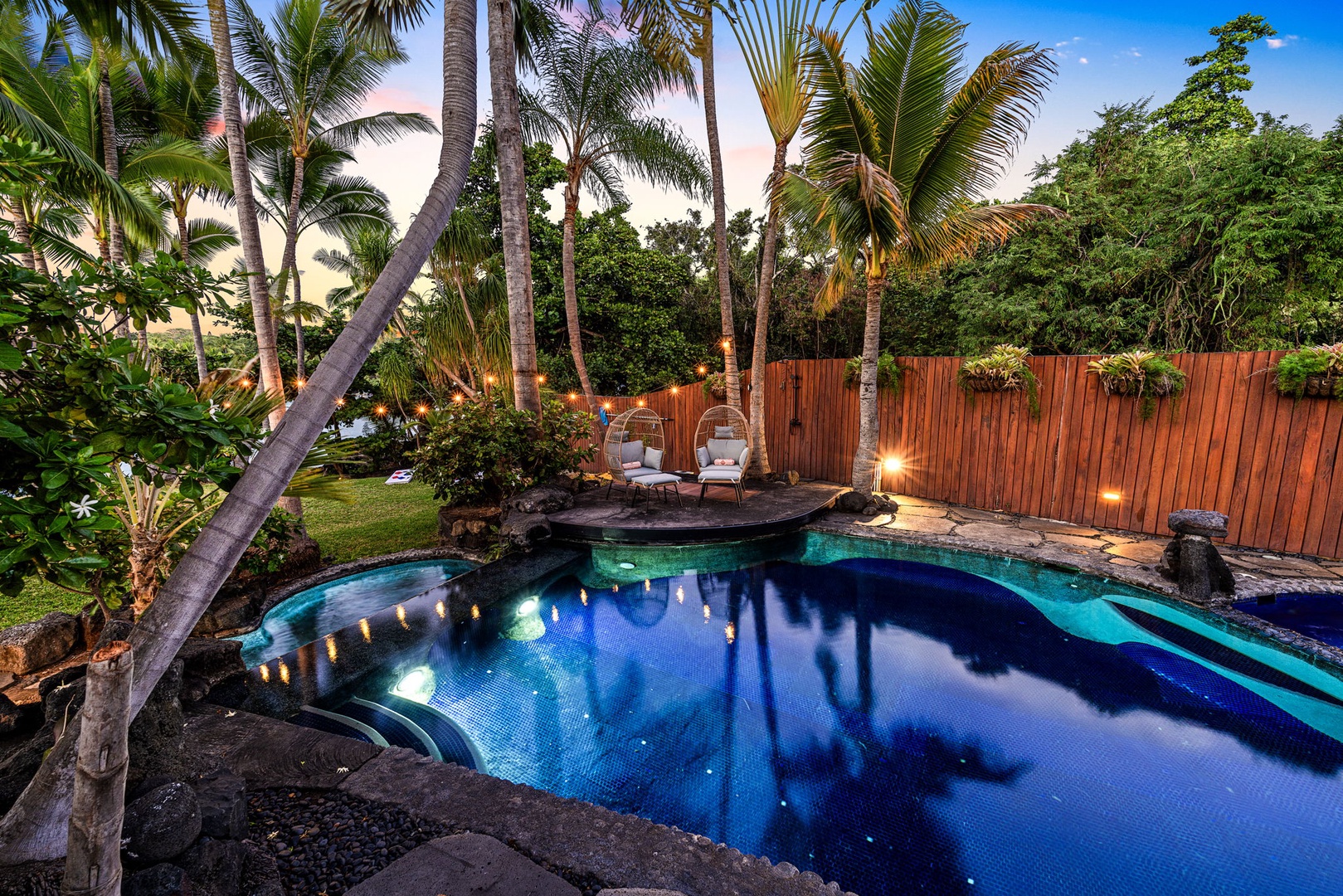 Kailua-Kona Vacation Rentals, Hahalua Bay Villa - Tropical paradise awaits in your private backyard oasis, featuring a stunning illuminated pool surrounded by picturesque landscape and cozy seating areas.