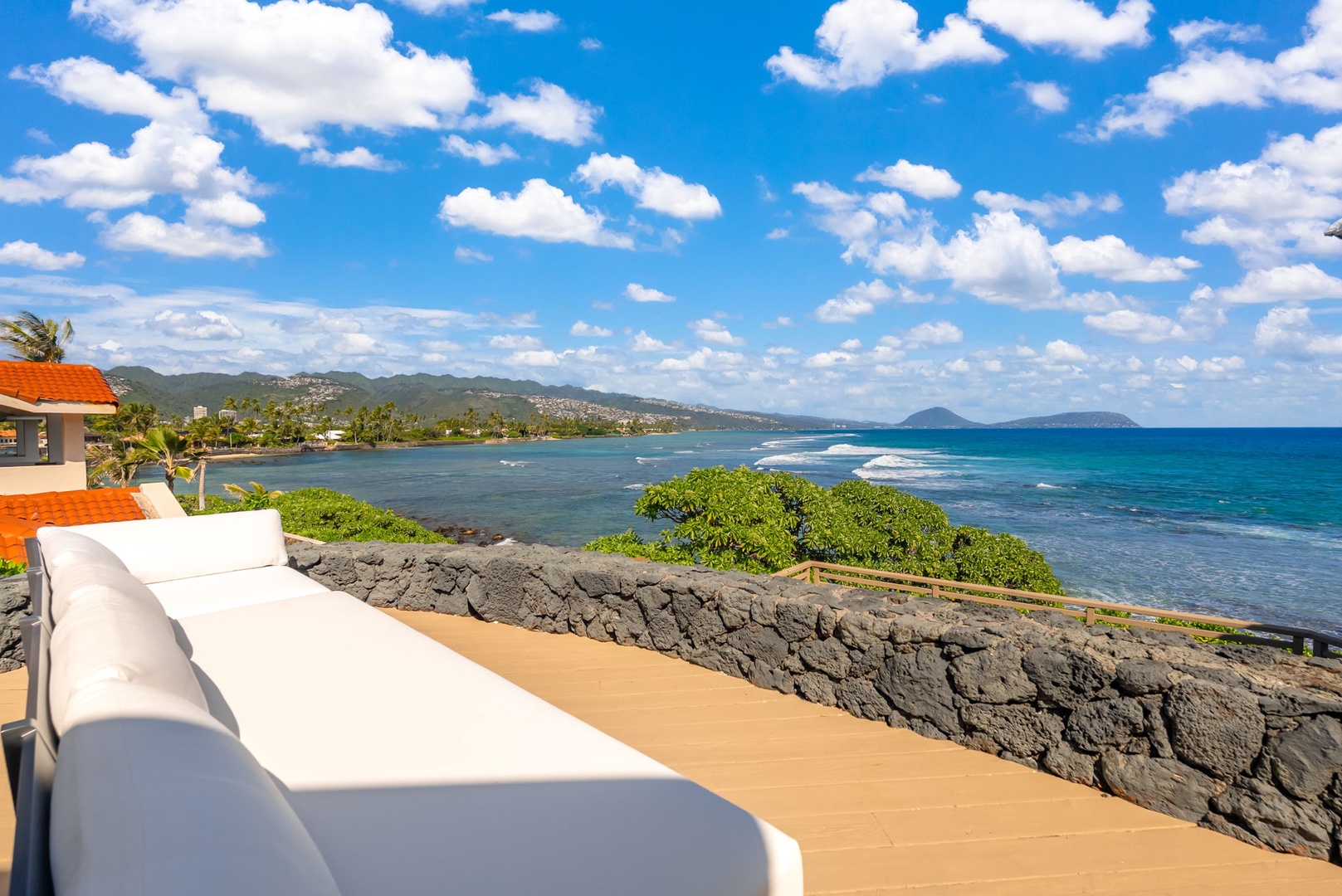 Honolulu Vacation Rentals, Black Point Ocean Villa - Oceanfront lanai showcases panoramic views of turquoise waters and distant islands from this elevated coastal retreat.