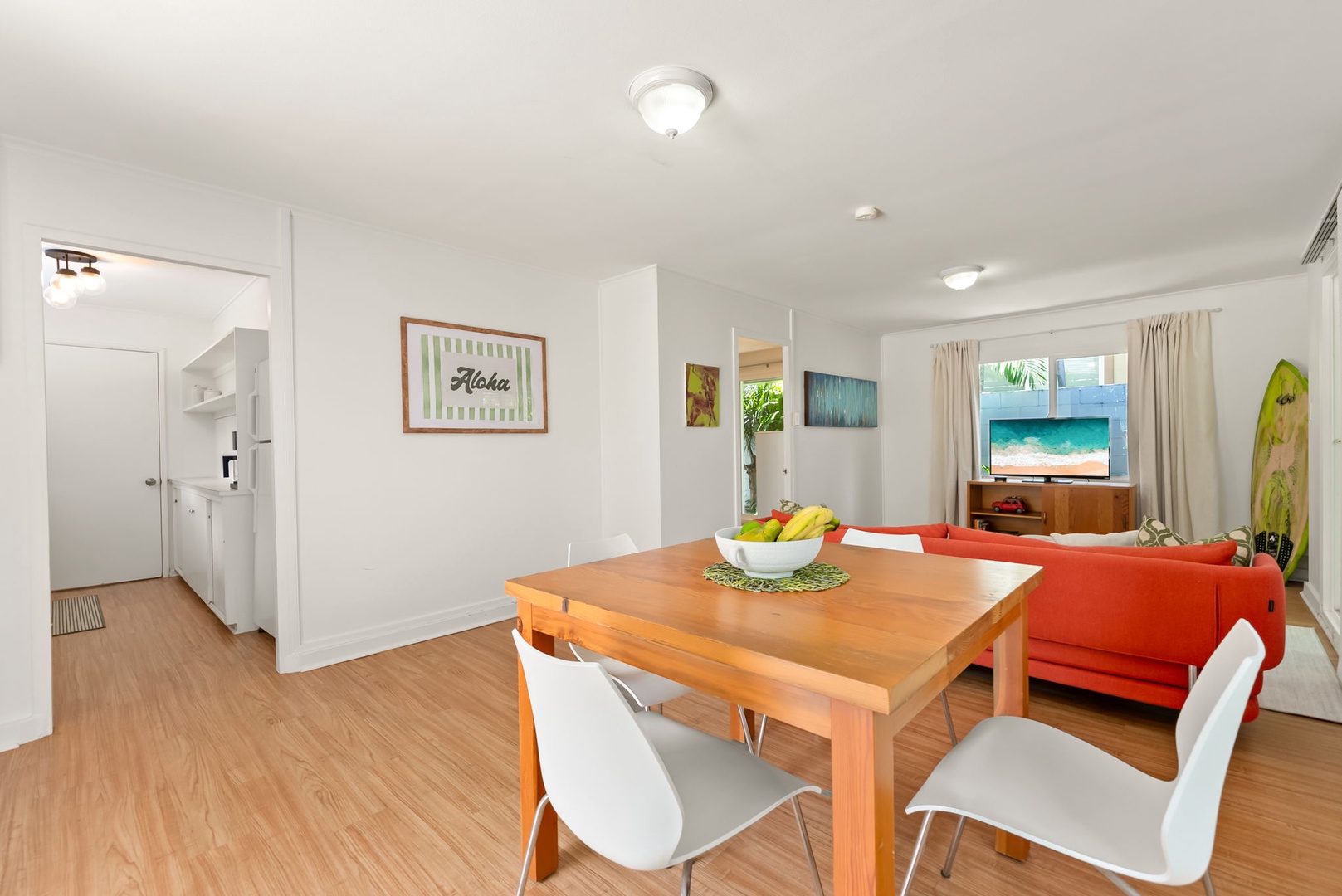 Honolulu Vacation Rentals, Ho'okipa Villa - Gather around the dining table where tropical touches meet island comfort—your breezy beach escape with vibrant pops of color and relaxed coastal vibes awaits.