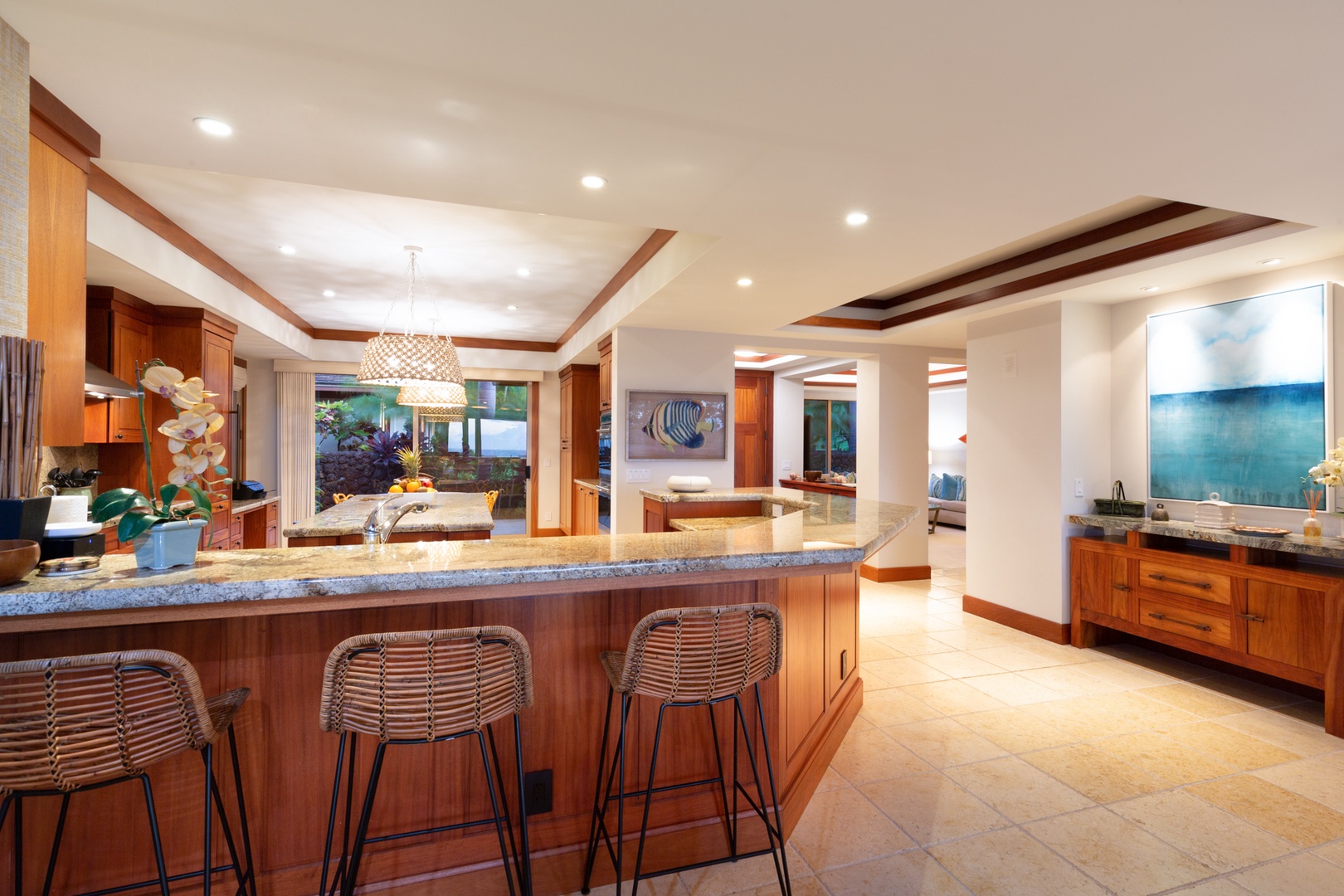 Kailua Kona Vacation Rentals, 4BD Hainoa Estate (102) at Four Seasons Resort at Hualalai - View of the kitchen featuring the bar seating with the media room beyond