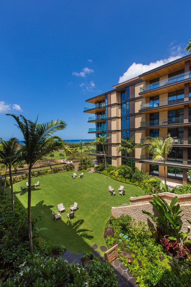 Honolulu Vacation Rentals, Park Lane Sunset Resort - Modern beachfront resort building with tropical landscaping and lawn area surrounded by palm trees and lush gardens.
