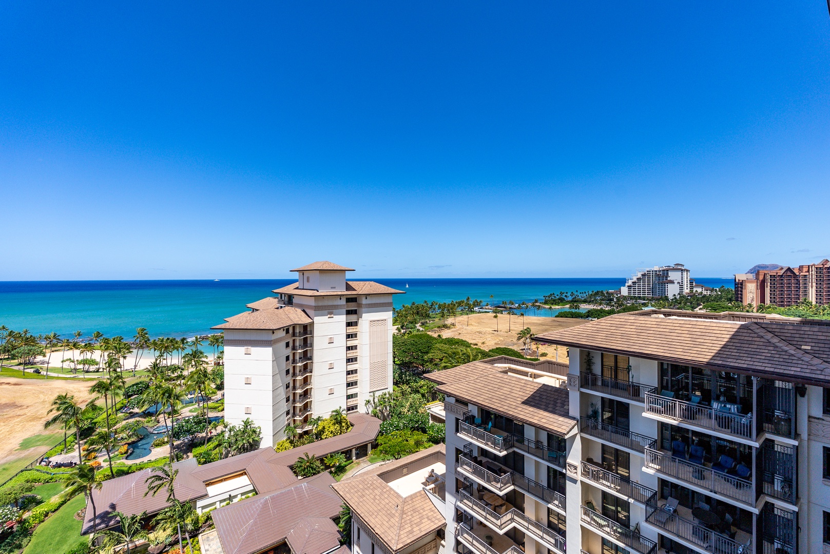 Kapolei Vacation Rentals, Ko Olina Beach Villas O1404 - Palms and rooftops give way to the lagoon and the ocean past them.