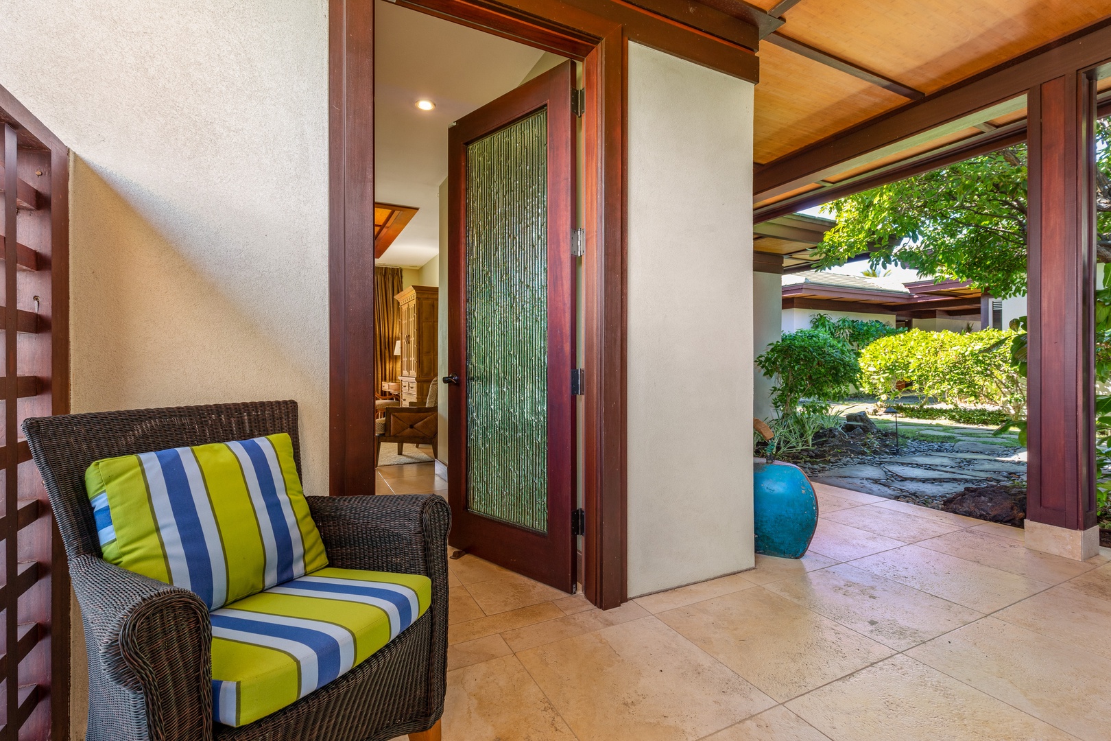 Kamuela Vacation Rentals, Champion Ridge Home - Private entryway with tropical seating and glass door detail.