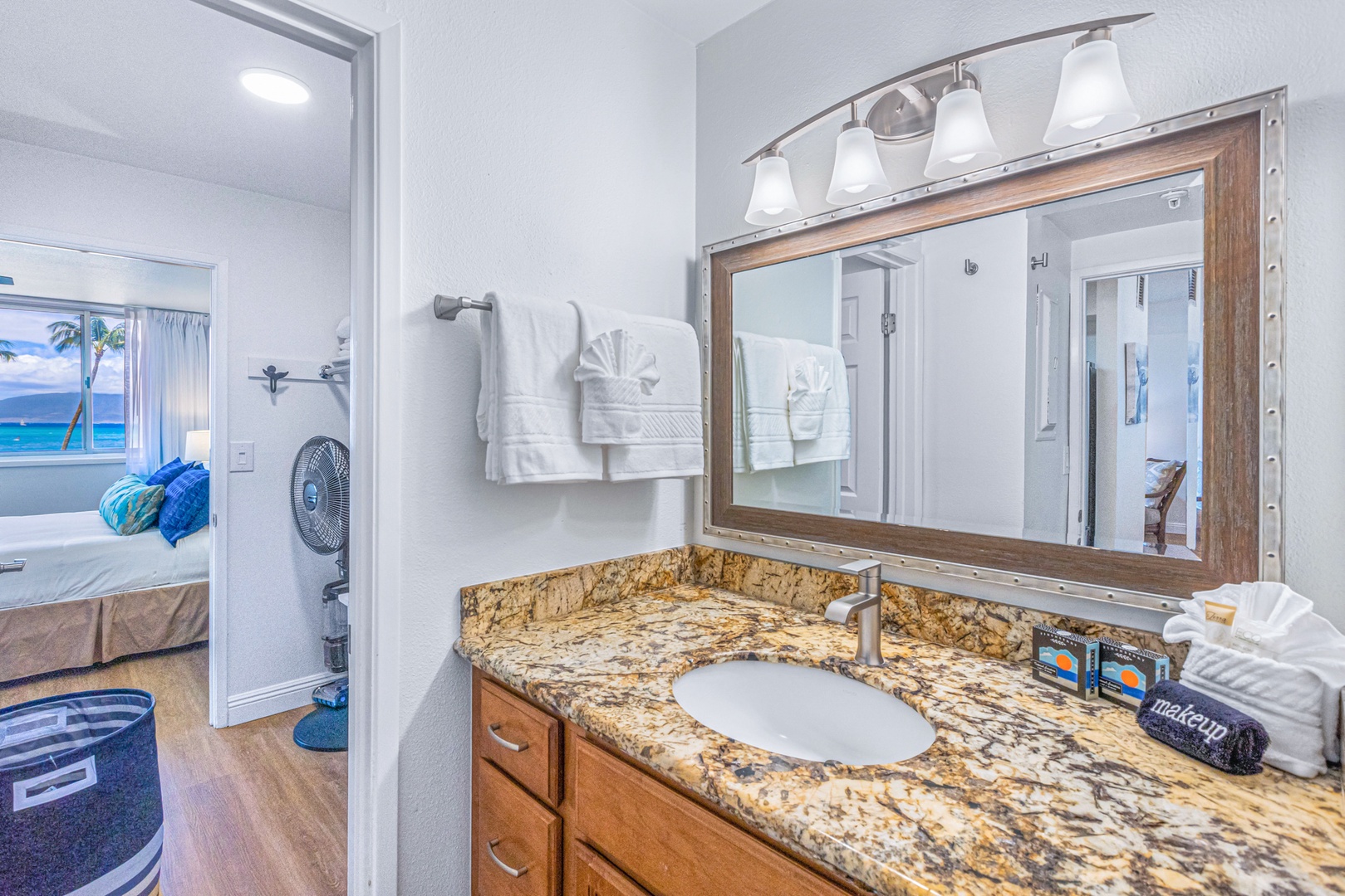 Lahaina Vacation Rentals, Royal Kahana 213 - This bathroom features a well-lit granite vanity and fresh towels, offering a comfortable and inviting space to refresh.