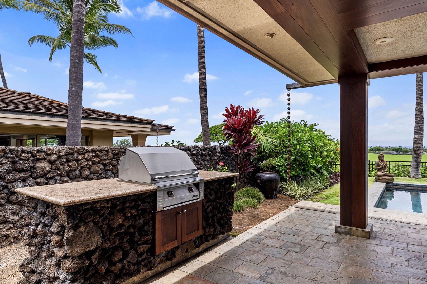 Kailua Kona Vacation Rentals, 3BD Pakui Street Estate (149) at Hualalai Resort - Grill dinner on the stone bar, the pool just beyond the greenery.