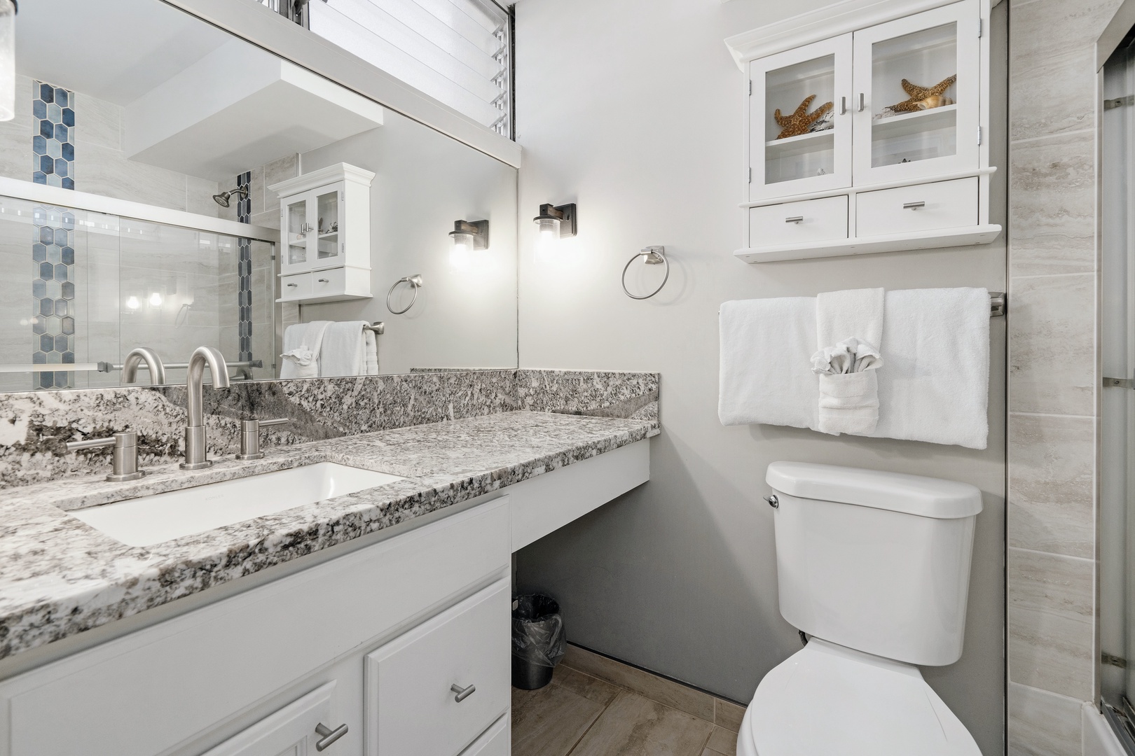 Kihei Vacation Rentals, Haleakala Shores A206 - A glass shower door and a blue tile accent give this bathroom a sleeker, more modern feel.