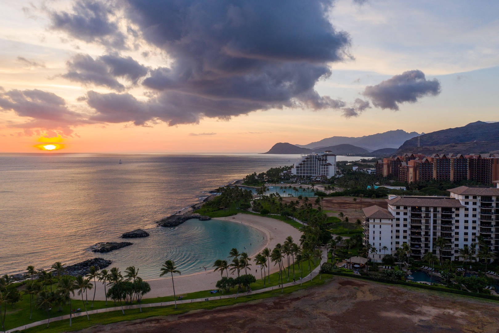 Kapolei Vacation Rentals, Ko Olina Beach Villas B604 - Stunning oceanfront resort complex with pristine beach, dramatic mountain backdrop, and spectacular sunset views over the Pacific waters.
