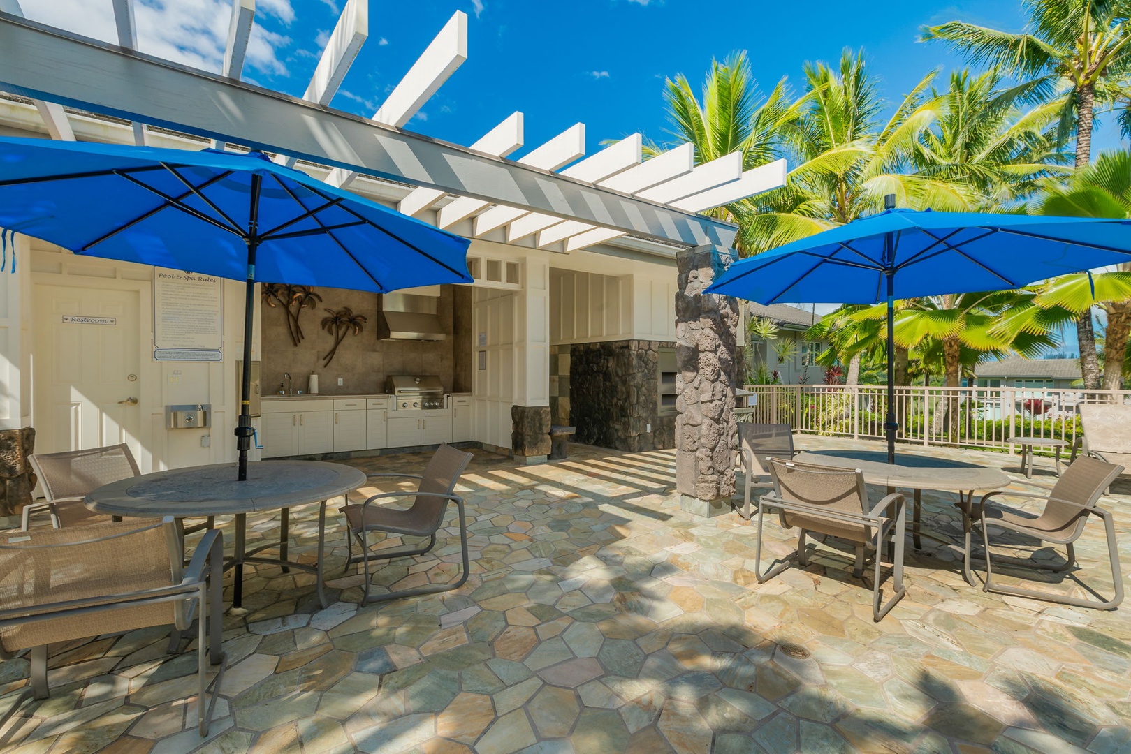 Princeville Vacation Rentals, Kaiulani #8 - Fire up the grills under blue umbrellas and eat poolside at the patio tables.