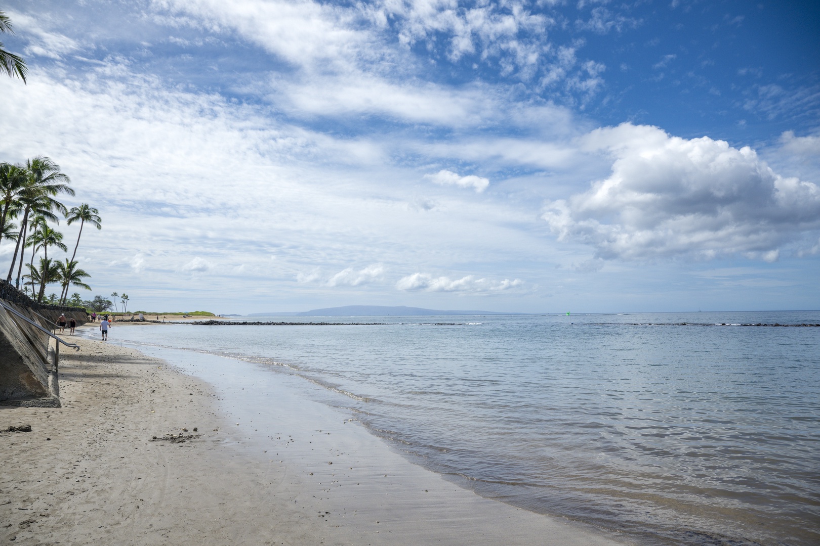 Kihei Vacation Rentals, Kihei Bay Surf B212 - Tropical beach with swaying palms and crystal-clear waters stretches along the coastline near the property.