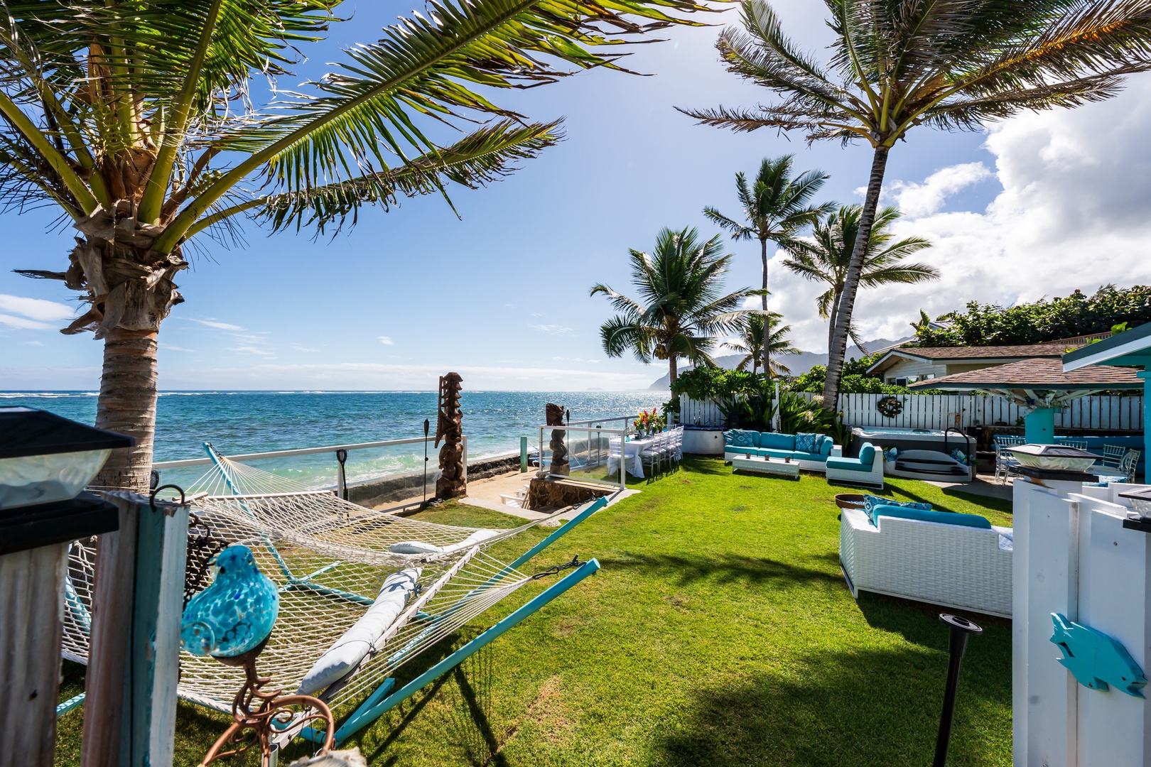 Hauula Vacation Rentals, Private Beach Paradise - Lush oceanfront lawn framed by palms, with the shoreline just steps away.