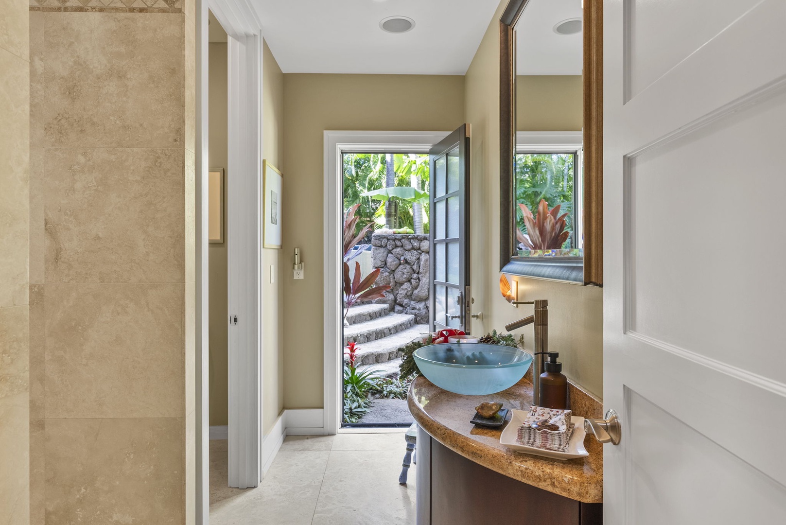 Honolulu Vacation Rentals, Pili Pono - Elegant bathroom with a vessel sink and direct access to a lush garden pathway.