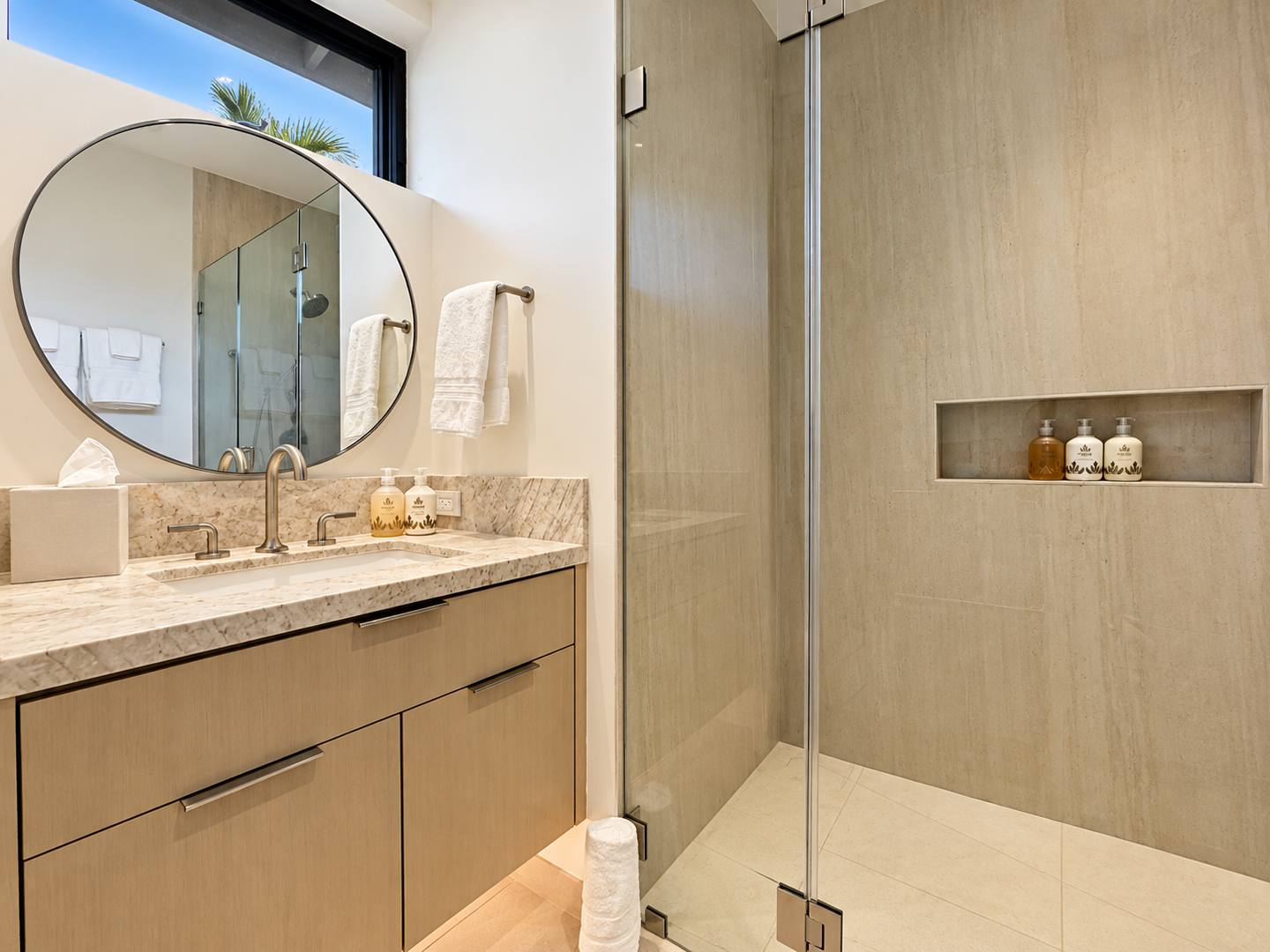Kamuela Vacation Rentals, 6BD Mauna Lani Lux Golf Estate (5) at One Ocean - A serene ensuite with a stone vanity, round mirror, and spacious glass-enclosed walk-in shower