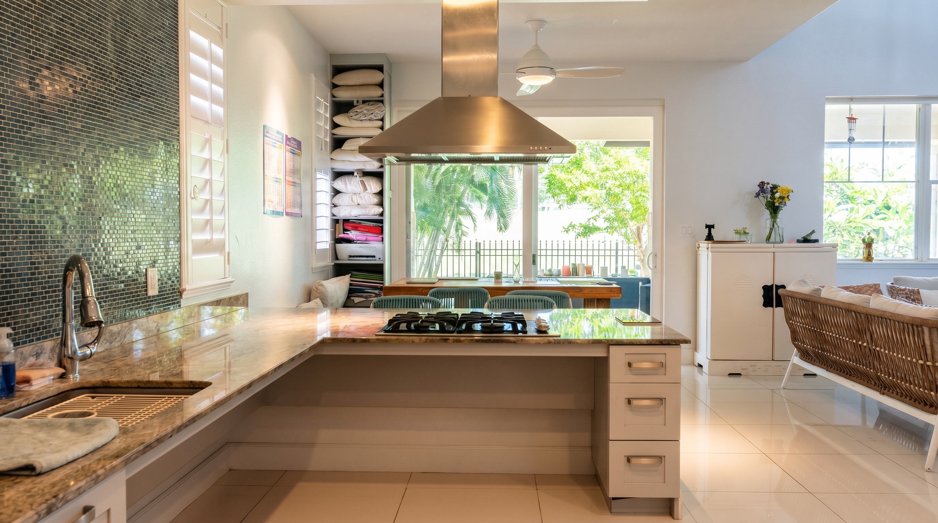 The gas cooktop faces a wide window of greenery, so whoever’s cooking gets the best seat in the kitchen.