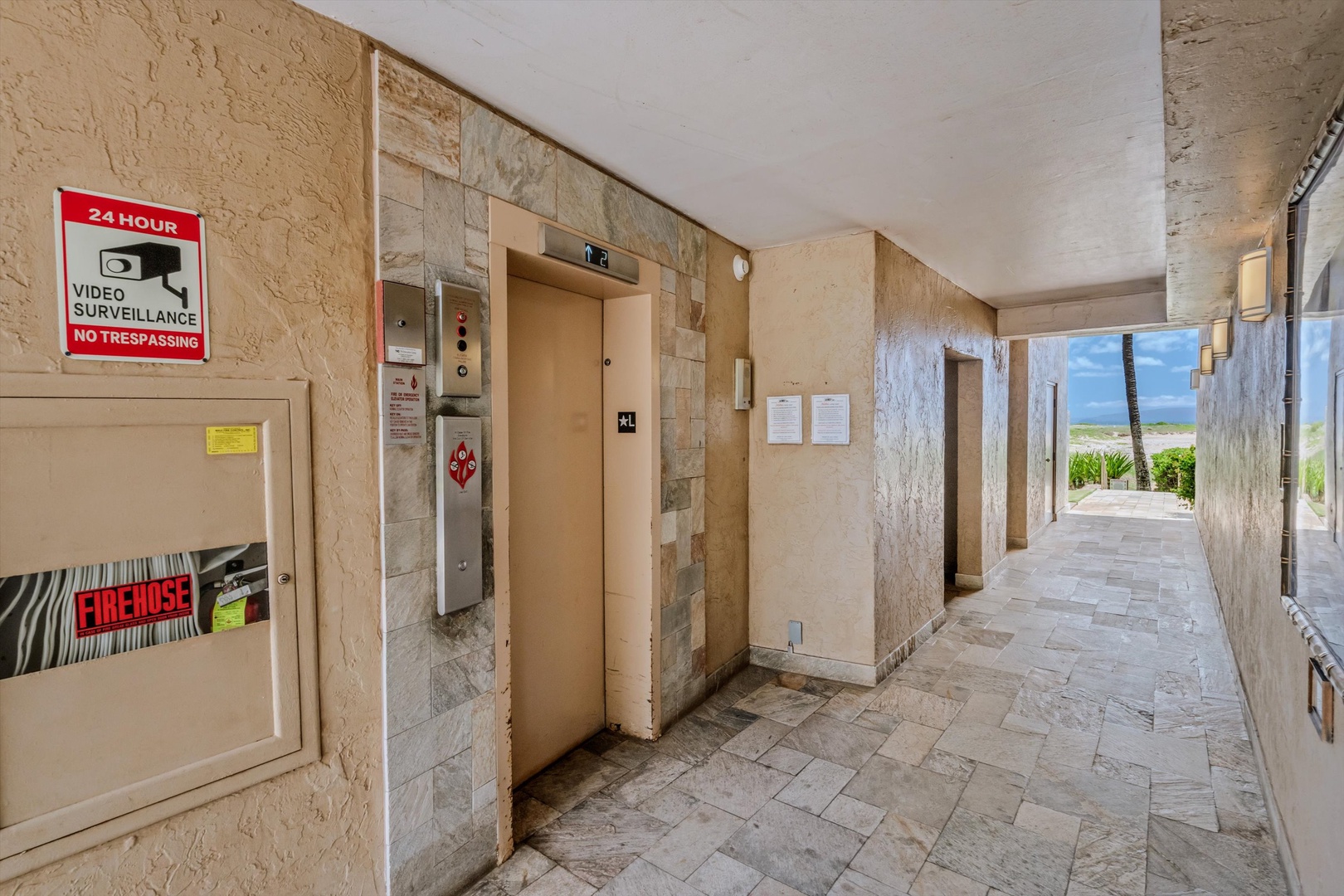 Kihei Vacation Rentals, Menehune Shores 420 - Ride the elevator down to a walkway that opens toward the lawn and beach.27