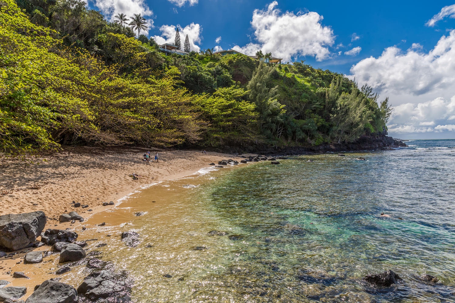 Princeville Vacation Rentals, Ola Hou - Main House - Crystal-clear waters at a secluded beach with a lush tropical backdrop.