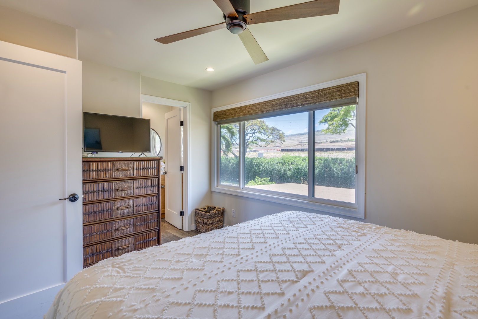 Lahaina Vacation Rentals, Puamana 240-3 - Unwind in this cozy bedroom featuring a queen-size bed and serene garden views through the window.