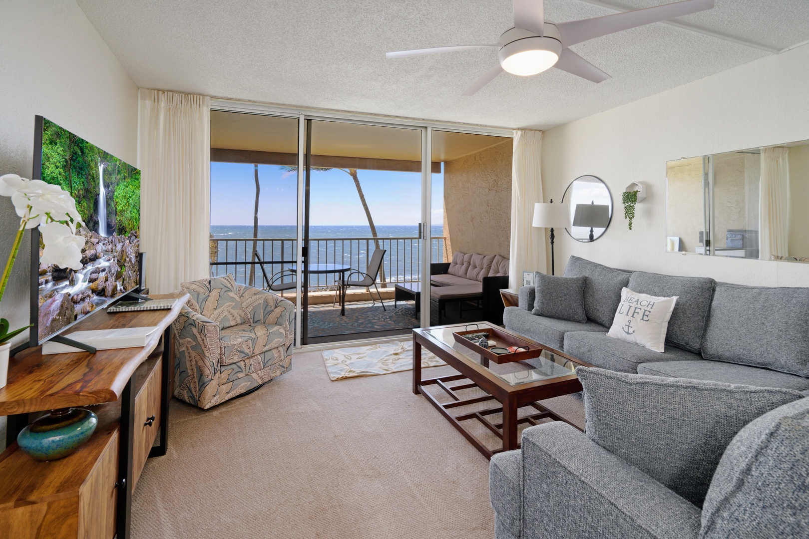 Kihei Vacation Rentals, Menehune Shores 316 - Palms sway just past the open slider, the ocean picking up right where the living room ends.