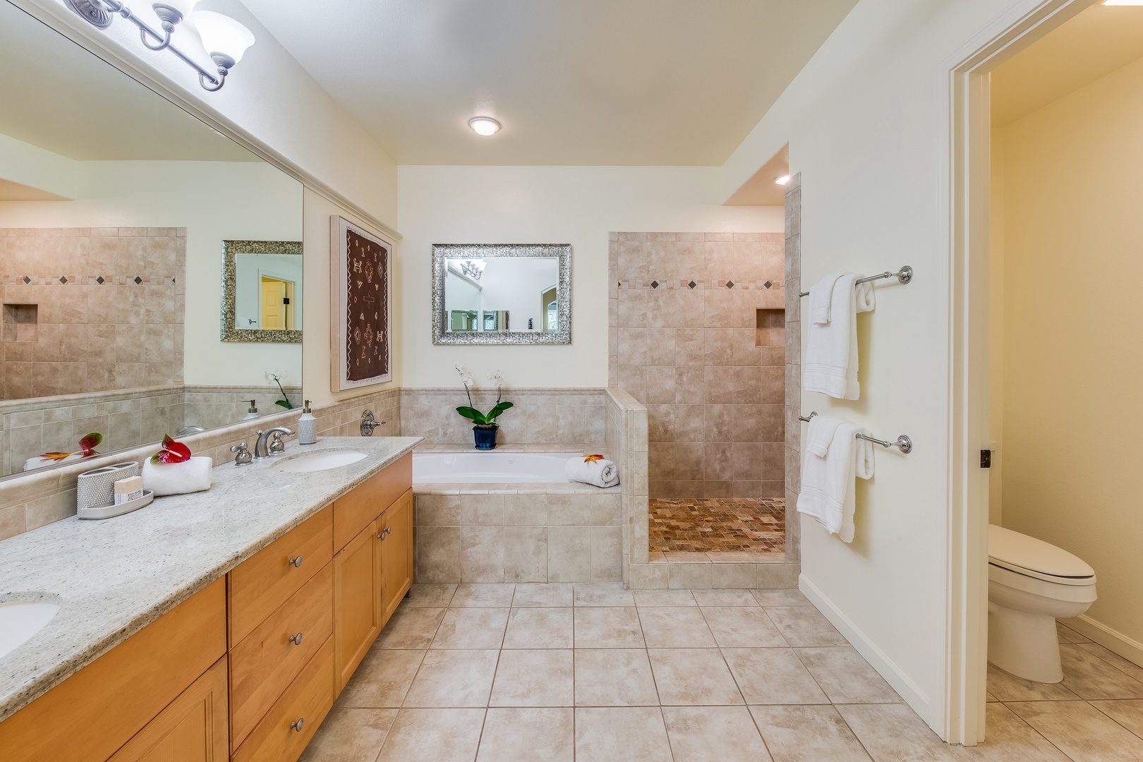 Kamuela Vacation Rentals, Mauna Lani Fairways #204 - This ensuite bathroom boasts a jetted tub, walk-in shower, and natural tile accents—comfort and luxury in perfect balance.