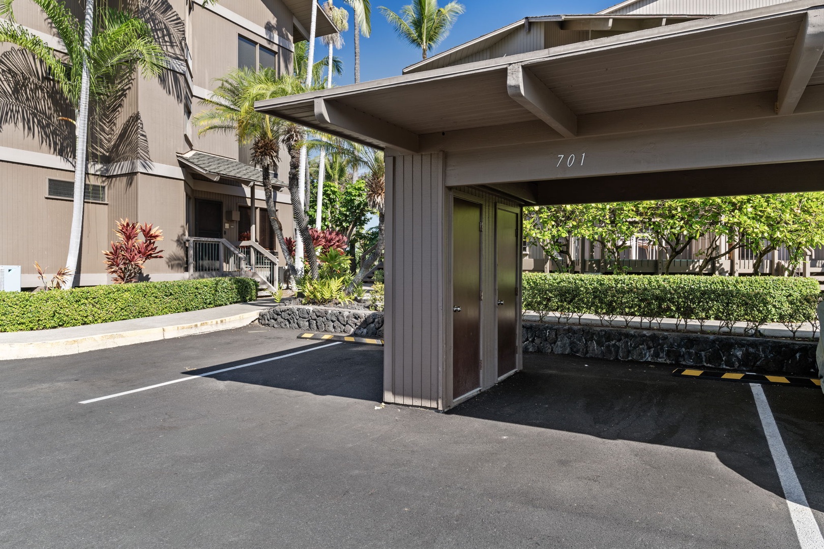 Kailua Kona Vacation Rentals, Kanaloa at Kona 701 - Covered parking space 701 provides convenient protection for your vehicle in this tropical Hawaiian setting with lush palm trees and landscaping.