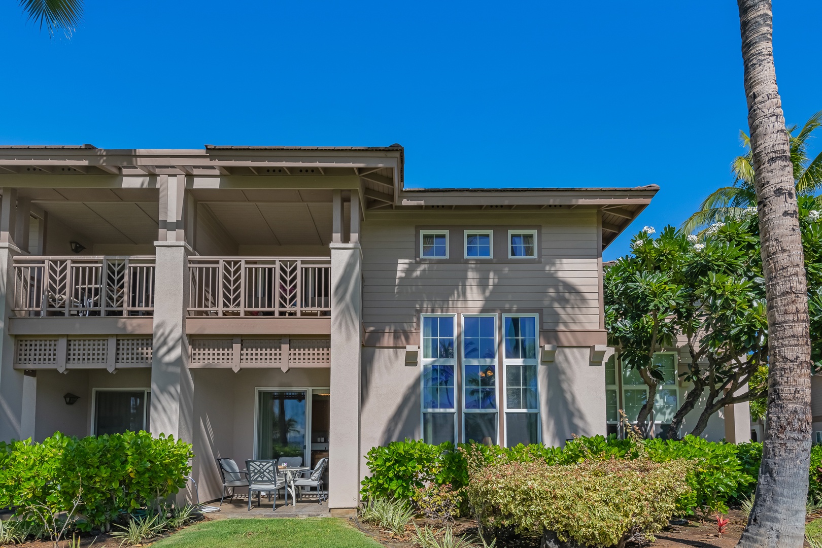 Waikoloa Vacation Rentals, Waikoloa Colony Villas 403 - View of the villa’s elegant exterior from the backyard, showcasing picture windows, private lanais, and lush surroundings.