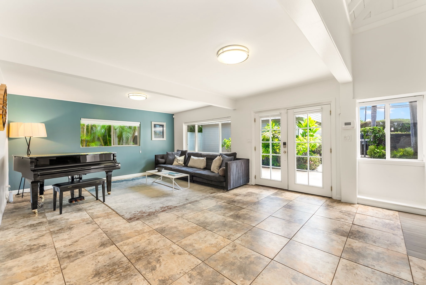 Honolulu Vacation Rentals, Ho'okipa Villa - Step into your bright, spacious living room where natural light floods through French doors, inviting you to unwind on plush seating or enjoy melodies at the grand piano.