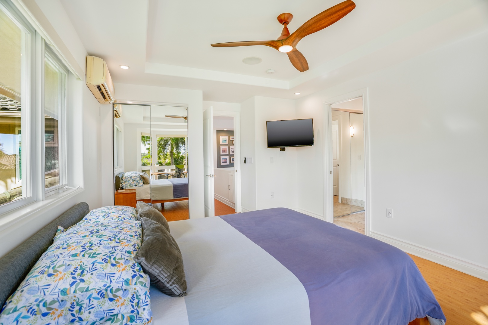 Princeville Vacation Rentals, Hale Kai - Your bright bedroom features a comfortable bed, wall-mounted TV, and ceiling fan for perfect relaxation after exploring.
