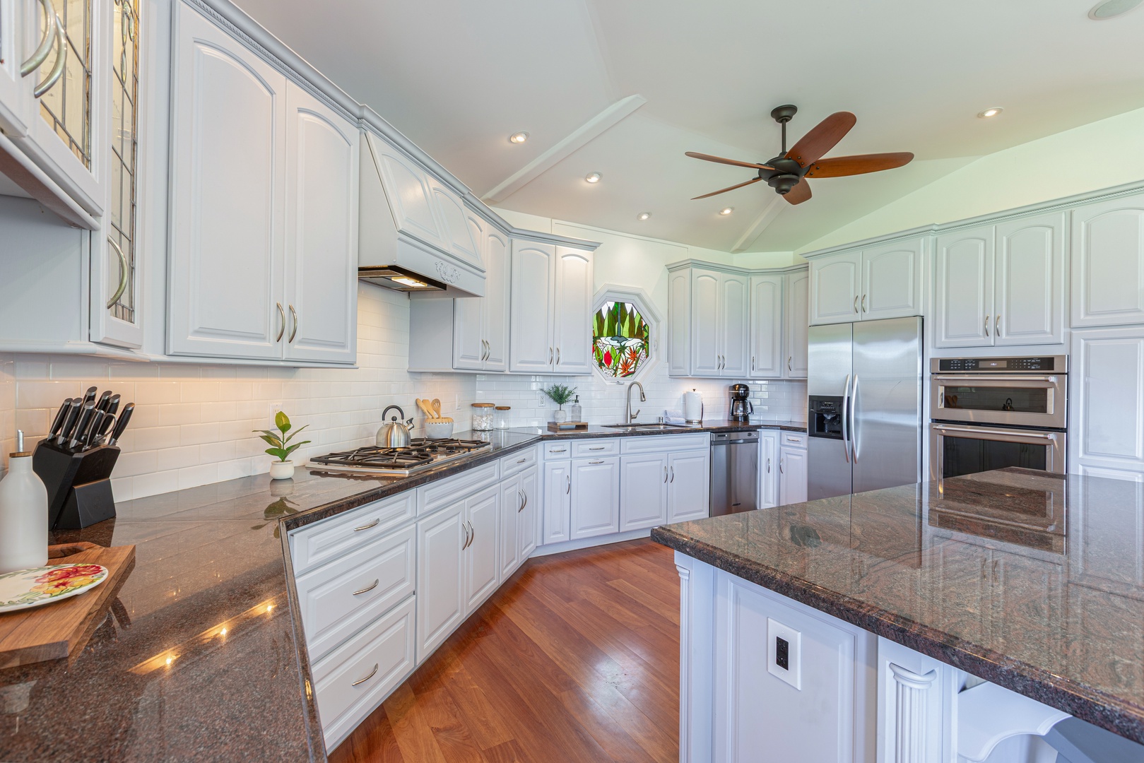 Princeville Vacation Rentals, Ohana Kamalani - Bright, elegant kitchen with high-end finishes, abundant storage, and direct access to dining and living areas.