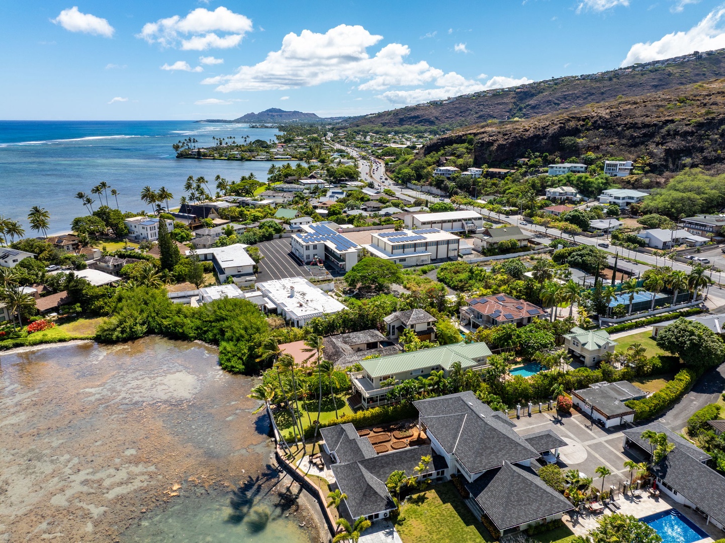 Honolulu Vacation Rentals, The Lagoon House 3BR - Aerial view of the coastal community, where homes meet the shoreline and green hills.