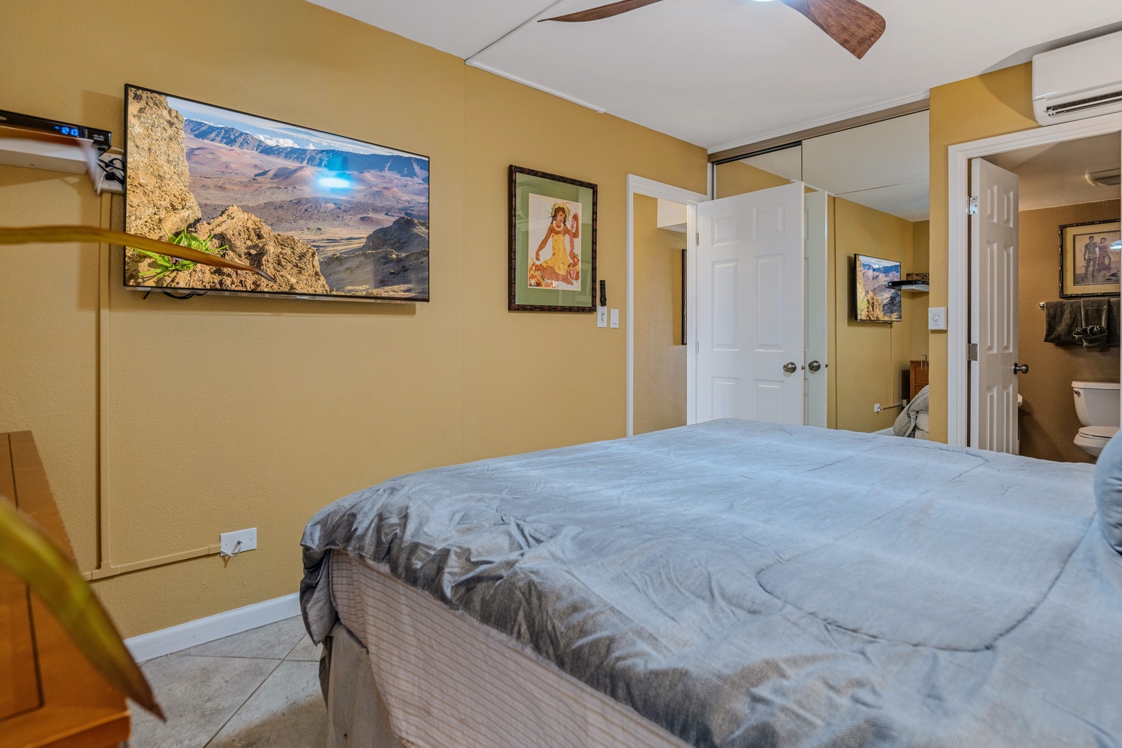 Kihei Vacation Rentals, Kamaole Sands 5310 - Your bedroom retreat features tropical-inspired artwork and a ceiling fan for optimal comfort.