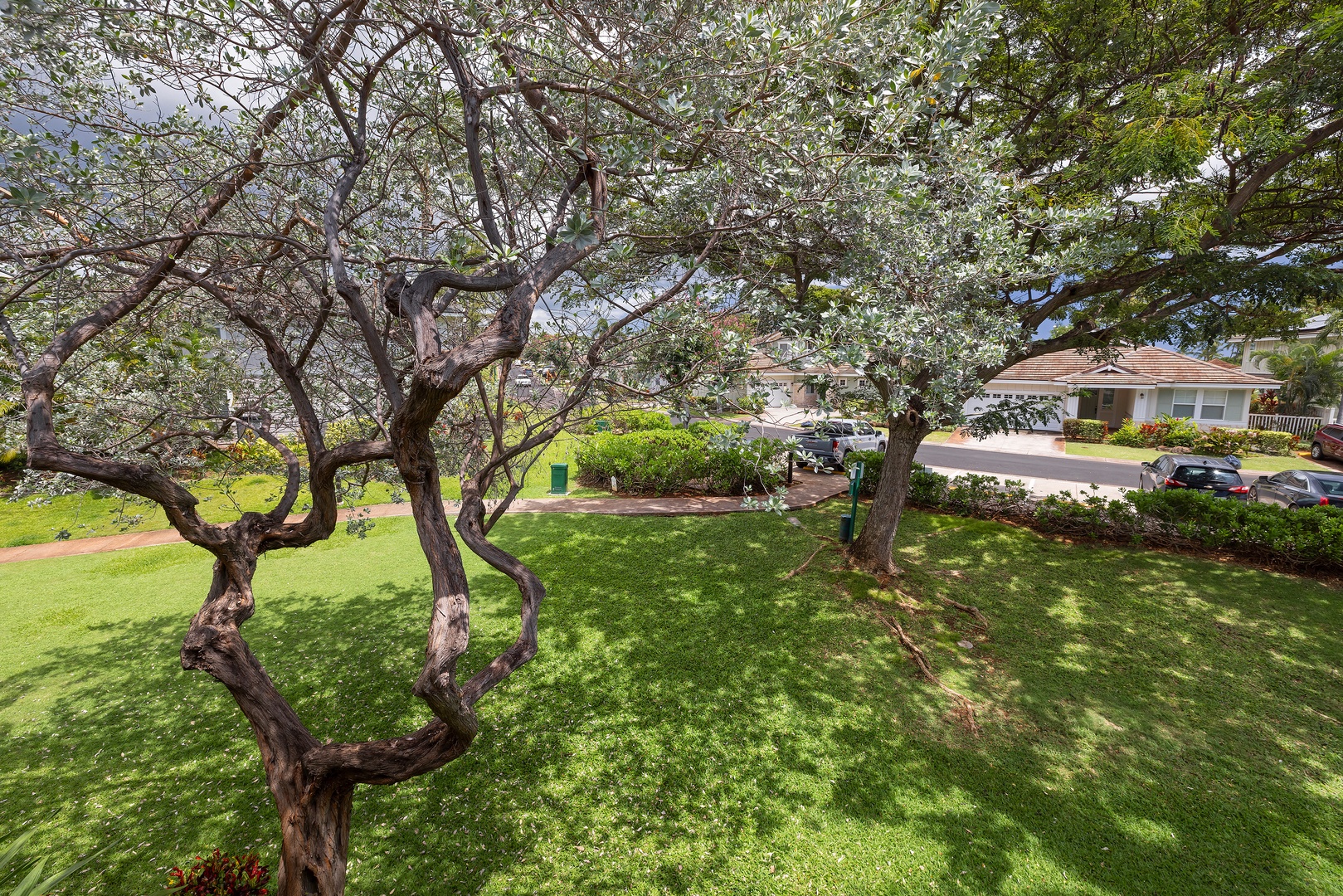 Kapolei Vacation Rentals, Ko Olina Kai 1105E - The property sits in a quiet residential neighborhood with mature trees and well-maintained grounds, offering a peaceful setting surrounded by lush greenery and nearby homes.