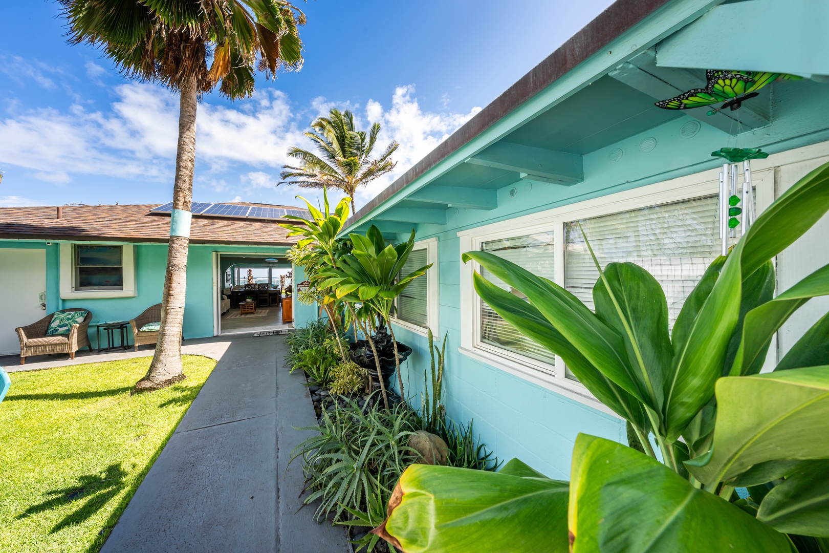 Hauula Vacation Rentals, Private Beach Paradise - A garden path along the house, ti leaves brushing the walk toward the water.