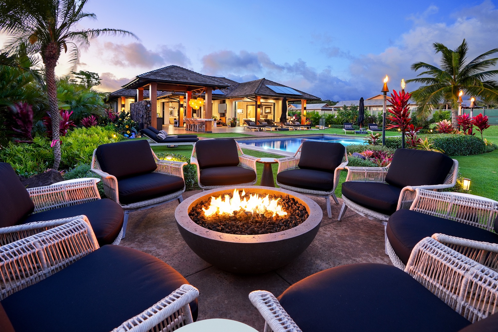 Koloa Vacation Rentals, Hale Pakika at Kukui'ula - Enjoy outdoor firepit elegance, offering views of the pool and lush tropical greenery.