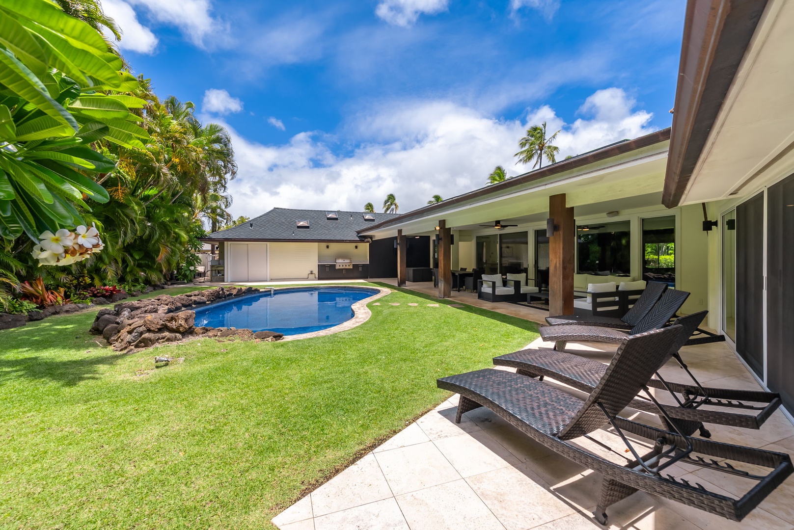 Honolulu Vacation Rentals, Kahala Lani - Poolside loungers ready for sunbathing with a backdrop of tropical greenery.
