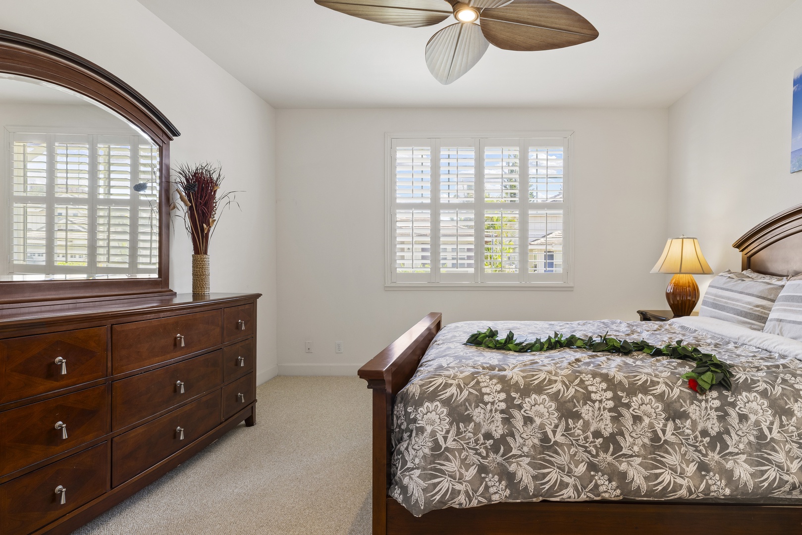 Wake up refreshed in the spacious primary bedroom, featuring a king bed, plantation shutters, and a peaceful setting designed for restful island nights.