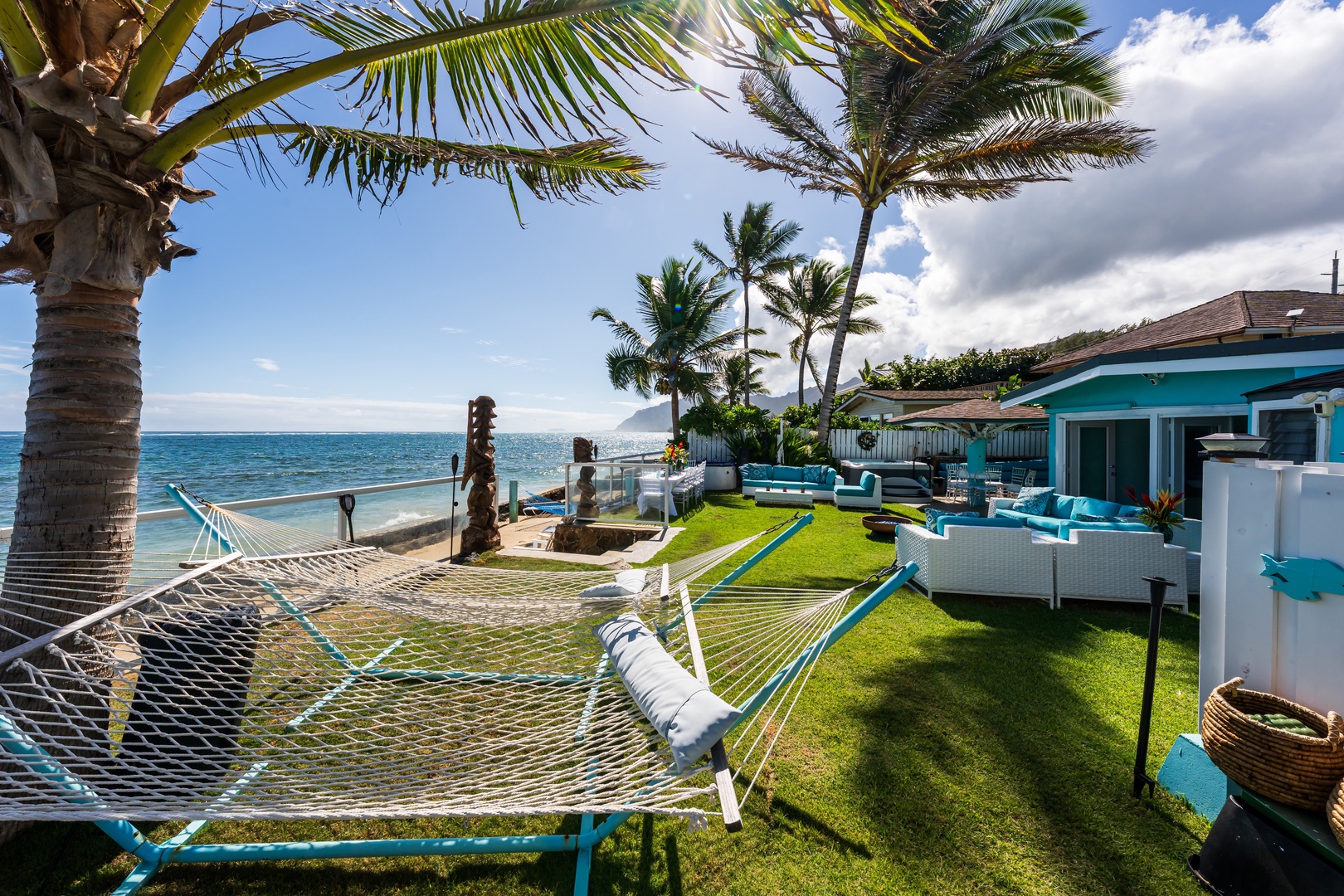 Hauula Vacation Rentals, Private Beach Paradise - Relaxing outdoor space with a hammock, palm trees, and sweeping Pacific views.