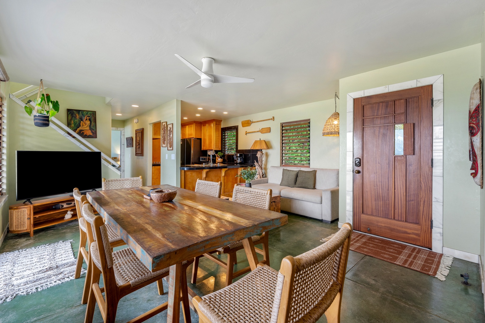 Hanalei Vacation Rentals, Hale Kepuhi - Gather around your wood dining table with woven chairs, where tropical breezes flow through your open-concept living space.