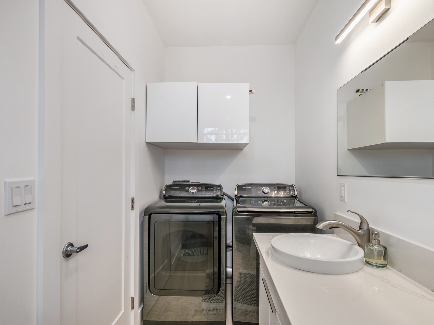 Haleiwa Vacation Rentals, Sunset Beach Island Retreat - The laundry room is equipped with modern appliances, offering a convenient washer and dryer setup.