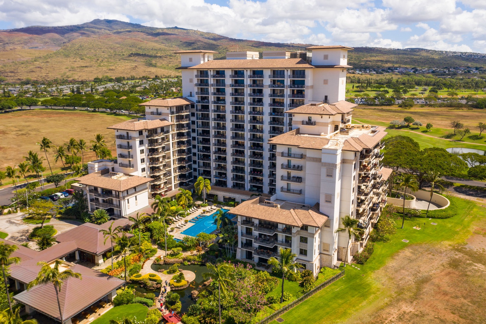 Kapolei Vacation Rentals, Ko Olina Beach Villas B604 - Resort complex surrounded by lush golf course and tropical mountains in Hawaii's scenic landscape.