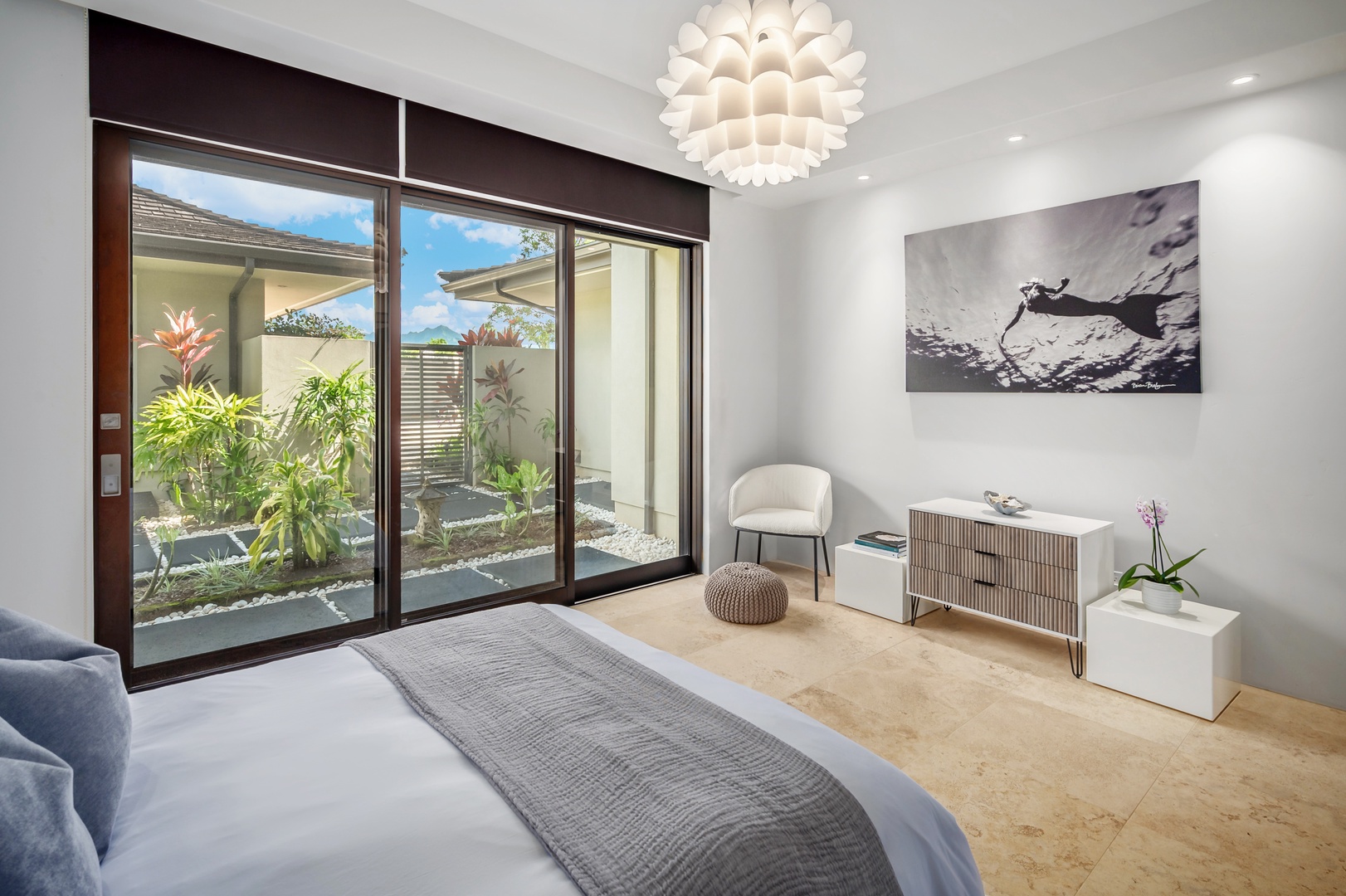 Princeville Vacation Rentals, Hanalei Plantation Villa - Serene bedroom with large sliding doors opening to lush garden views, creating a peaceful ambiance.