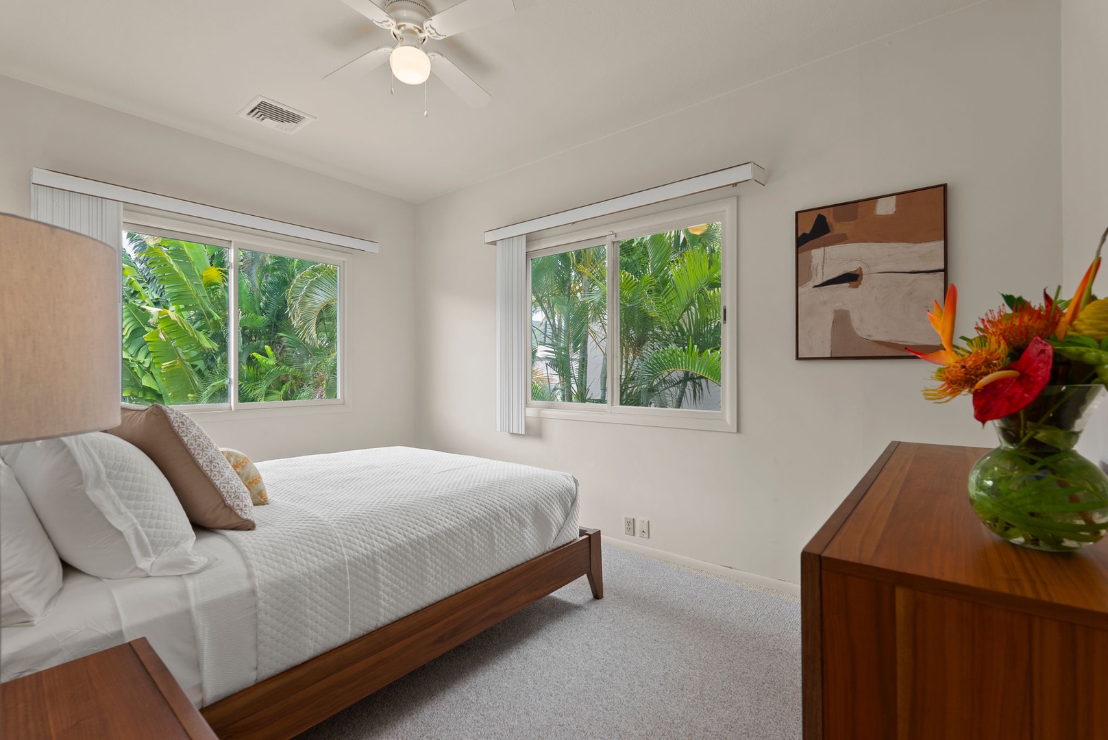 Honolulu Vacation Rentals, Paradise Beach Estate - This bright and breezy guest bedroom features a queen bed, ceiling fan, and tranquil views of the tropical landscaping.